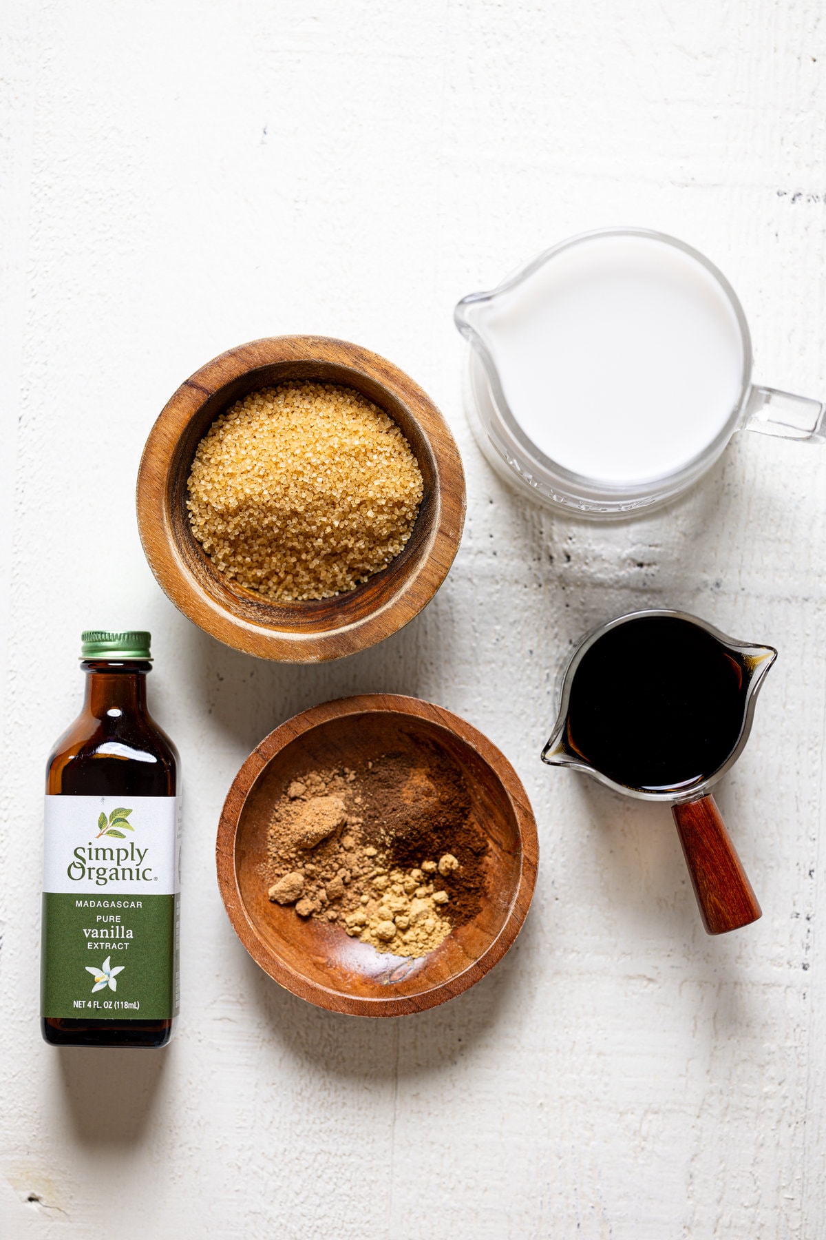 Ingredients for a Fall Spice Latte including vanilla extract, almond milk, and seasonings