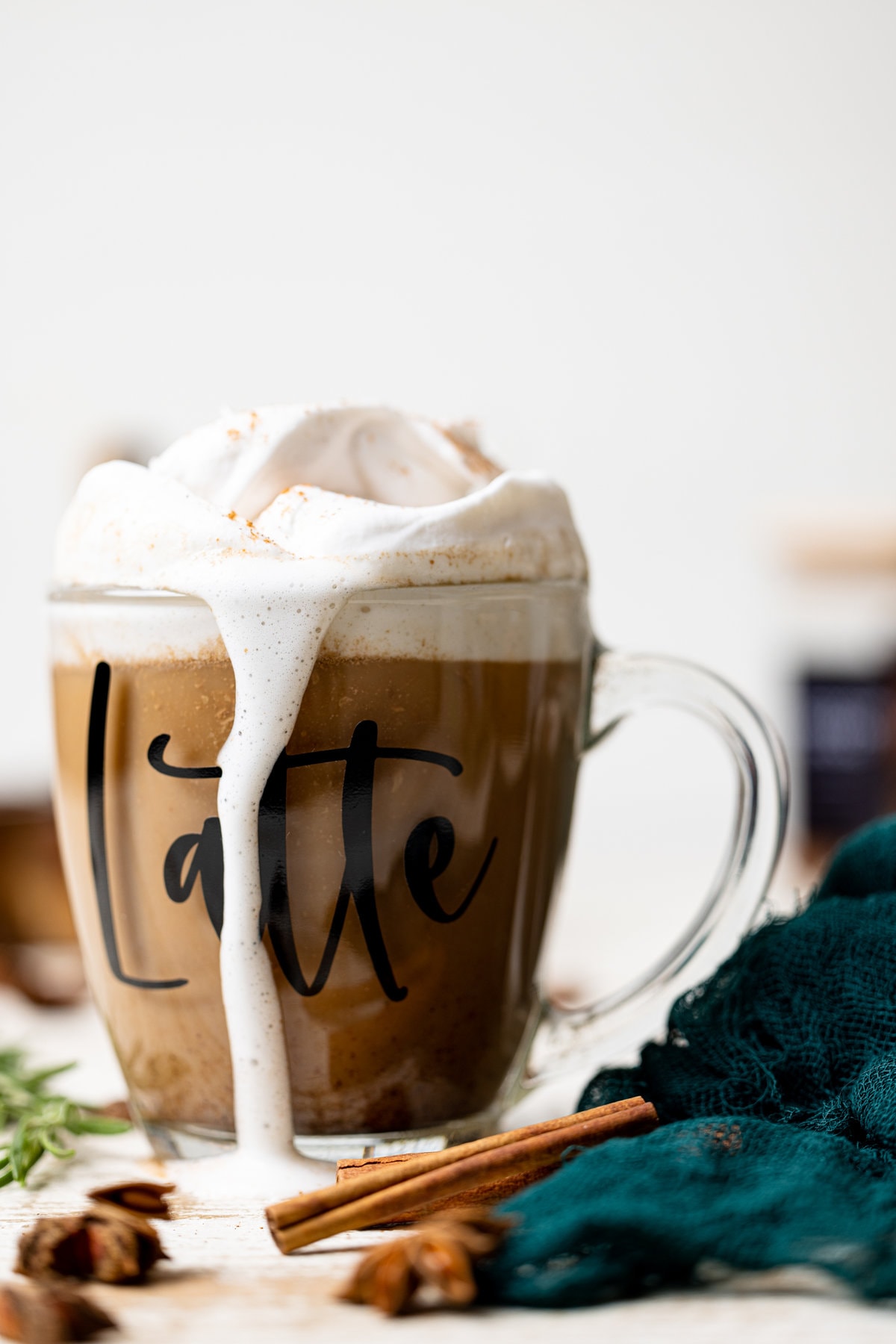 Overflowing glass of Fall Spice Latte with the word \"Latte\" on the side