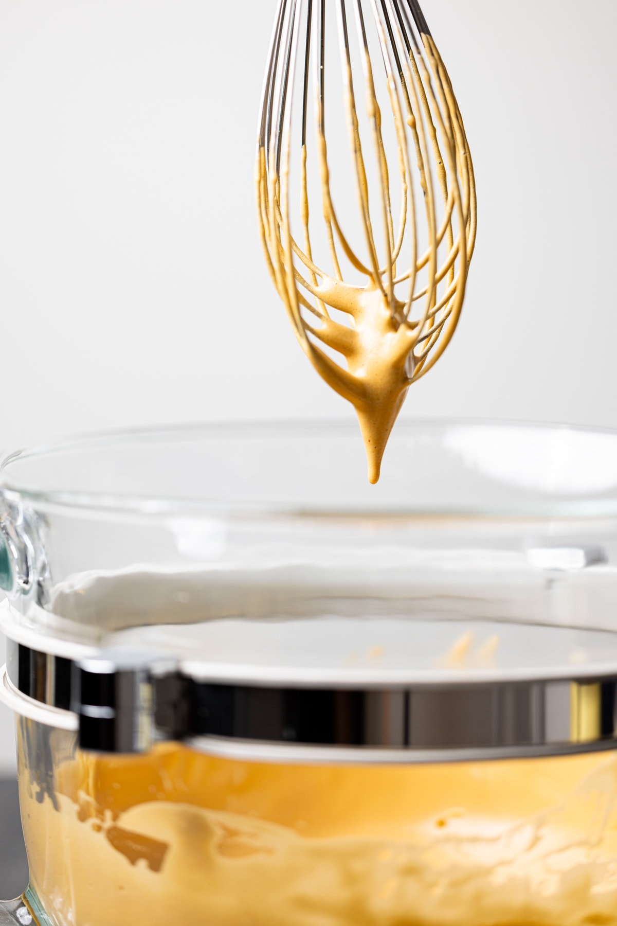 Whisk dripping with brown foam