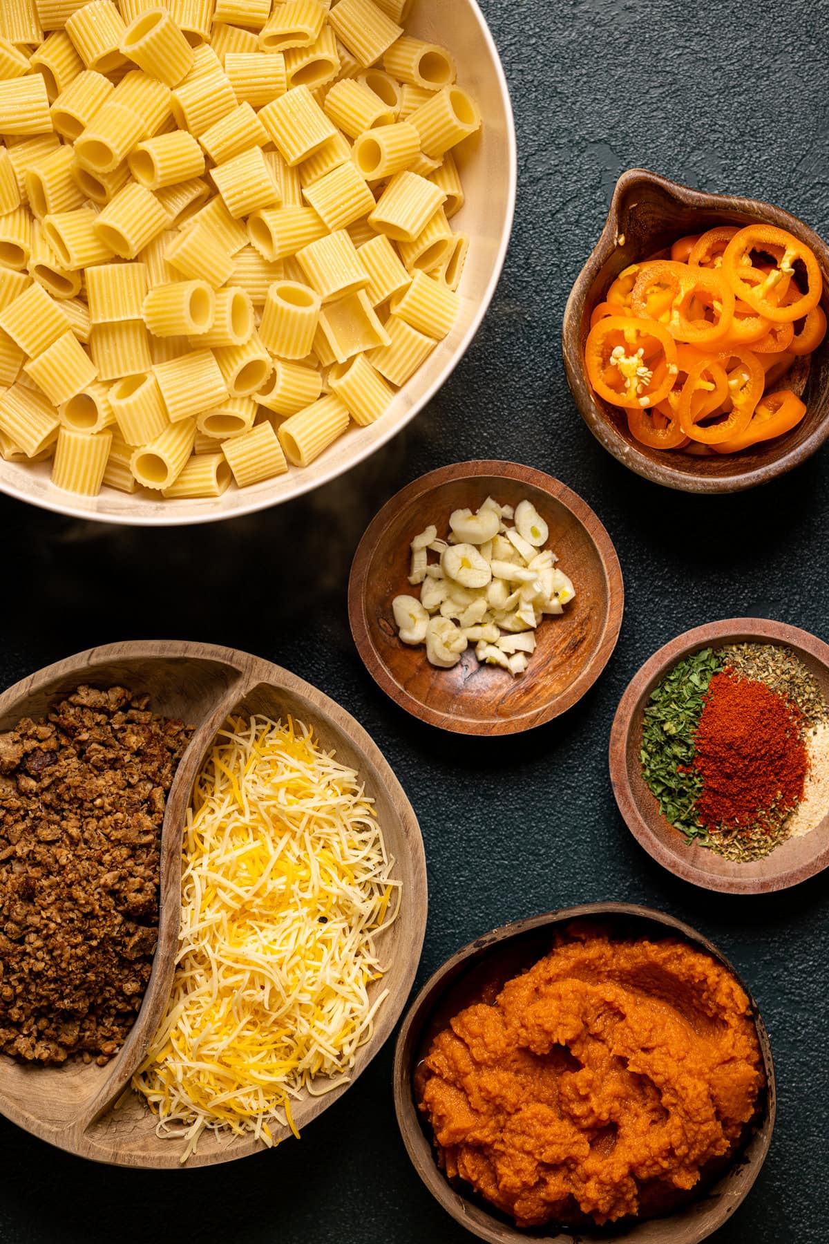 Ingredients for a Spicy Pumpkin Pasta Bake including peppers, garlic, and noodles