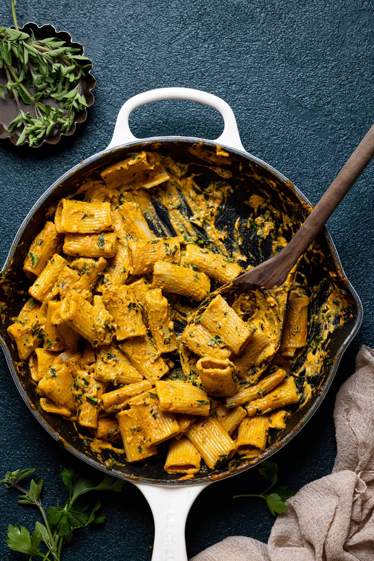 Wooden spoon scooping Spicy Brown Butter Pumpkin Rigatoni out of a skillet