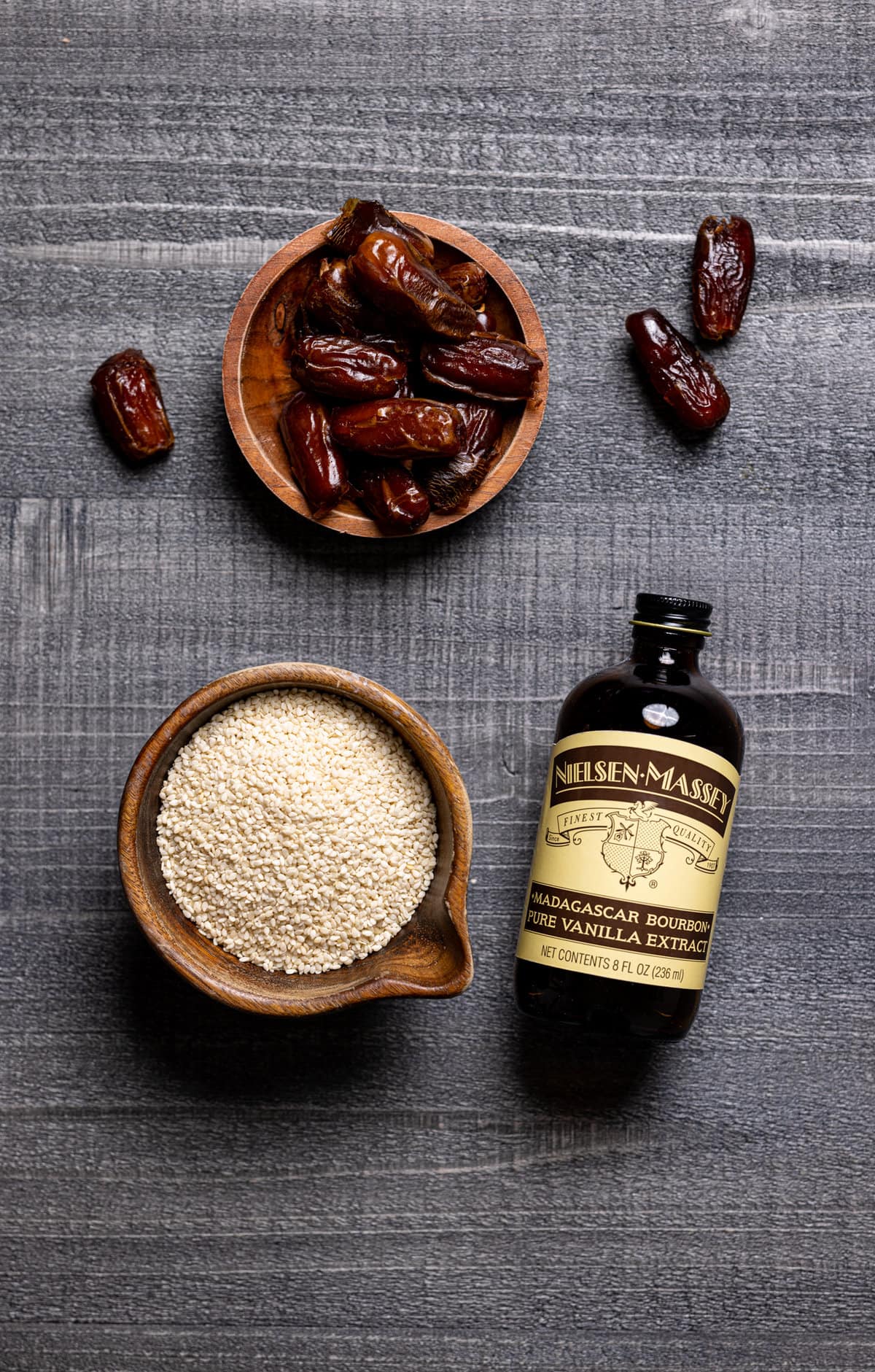 Some ingredients for Creamy Vanilla Sesame Milk: dates, vanilla extract, and sesame seeds