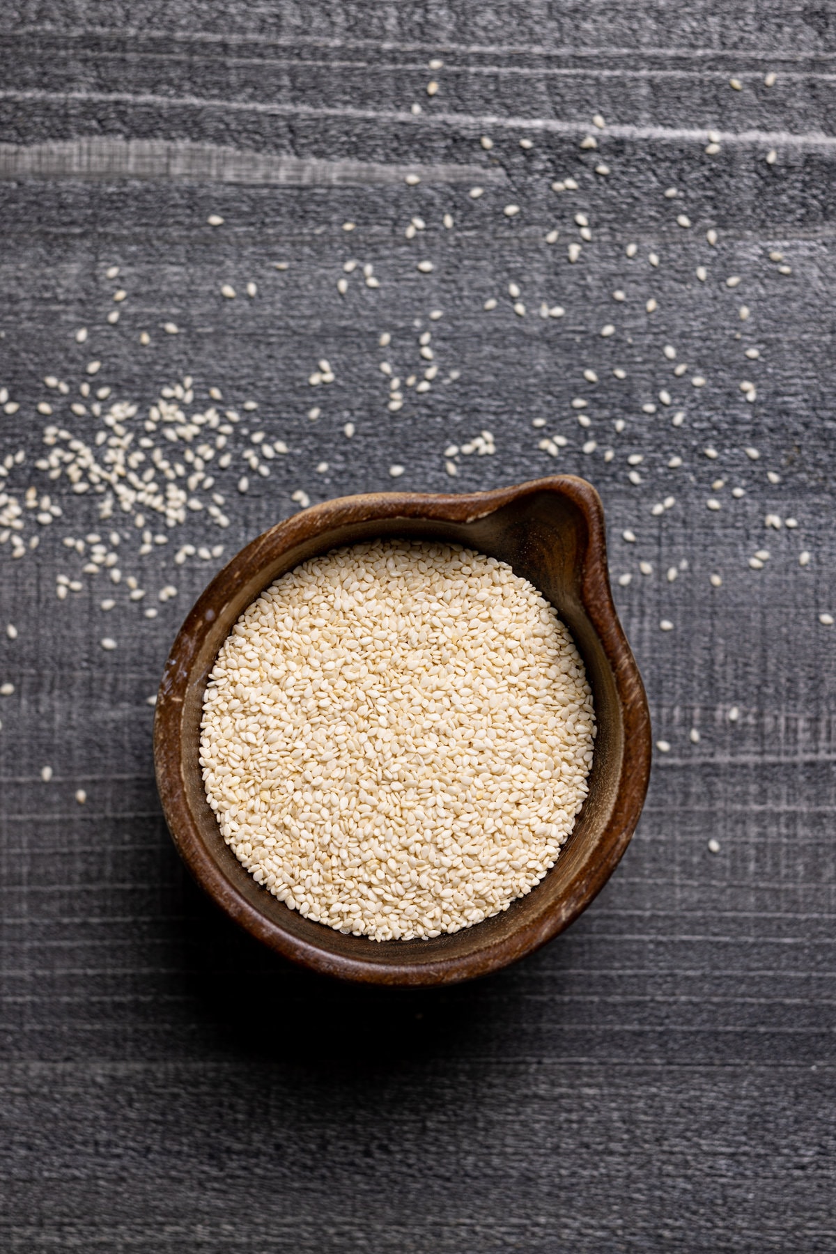 Small wooden bowl of sesame seeds