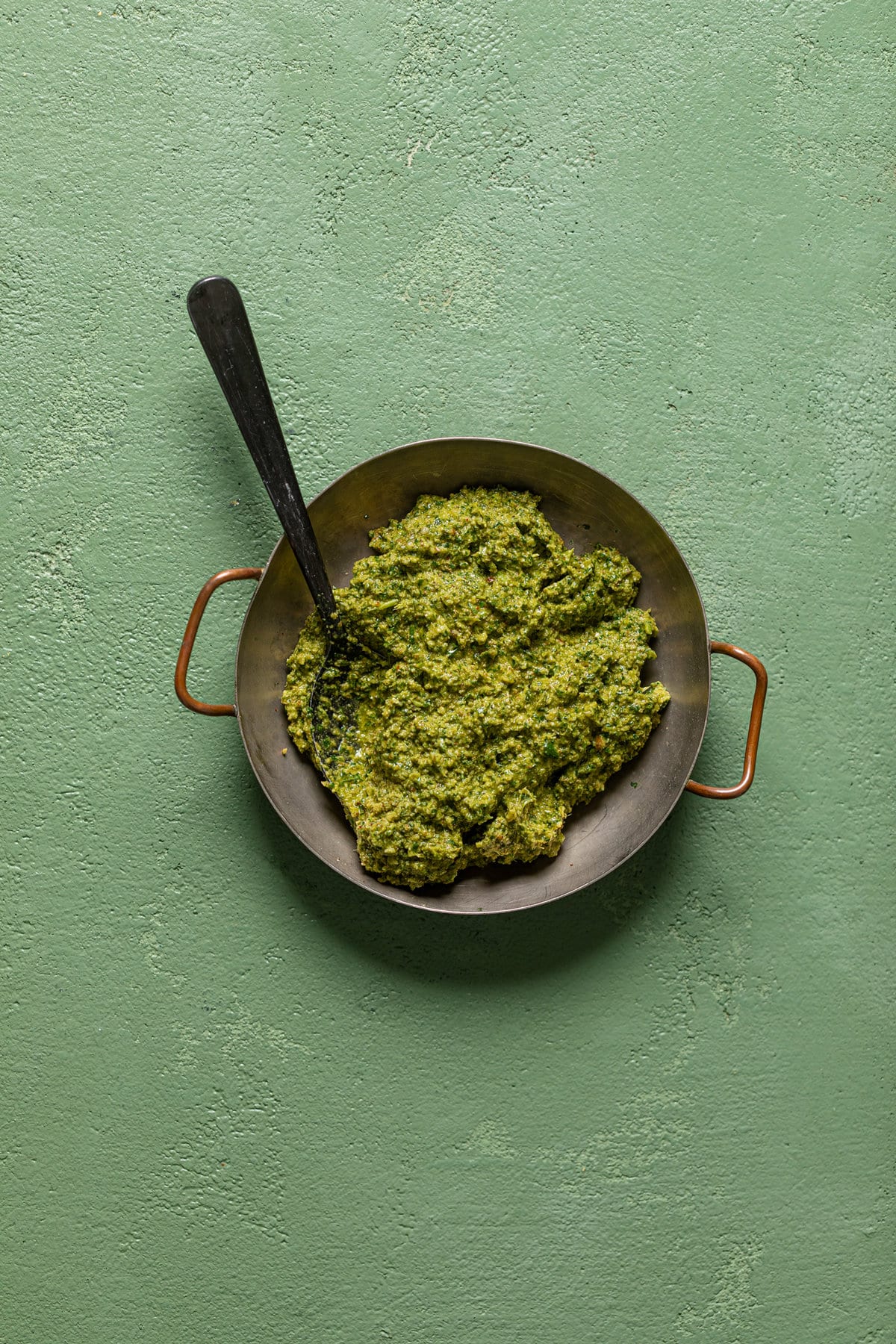 Spoon in a bowl of spinach pesto