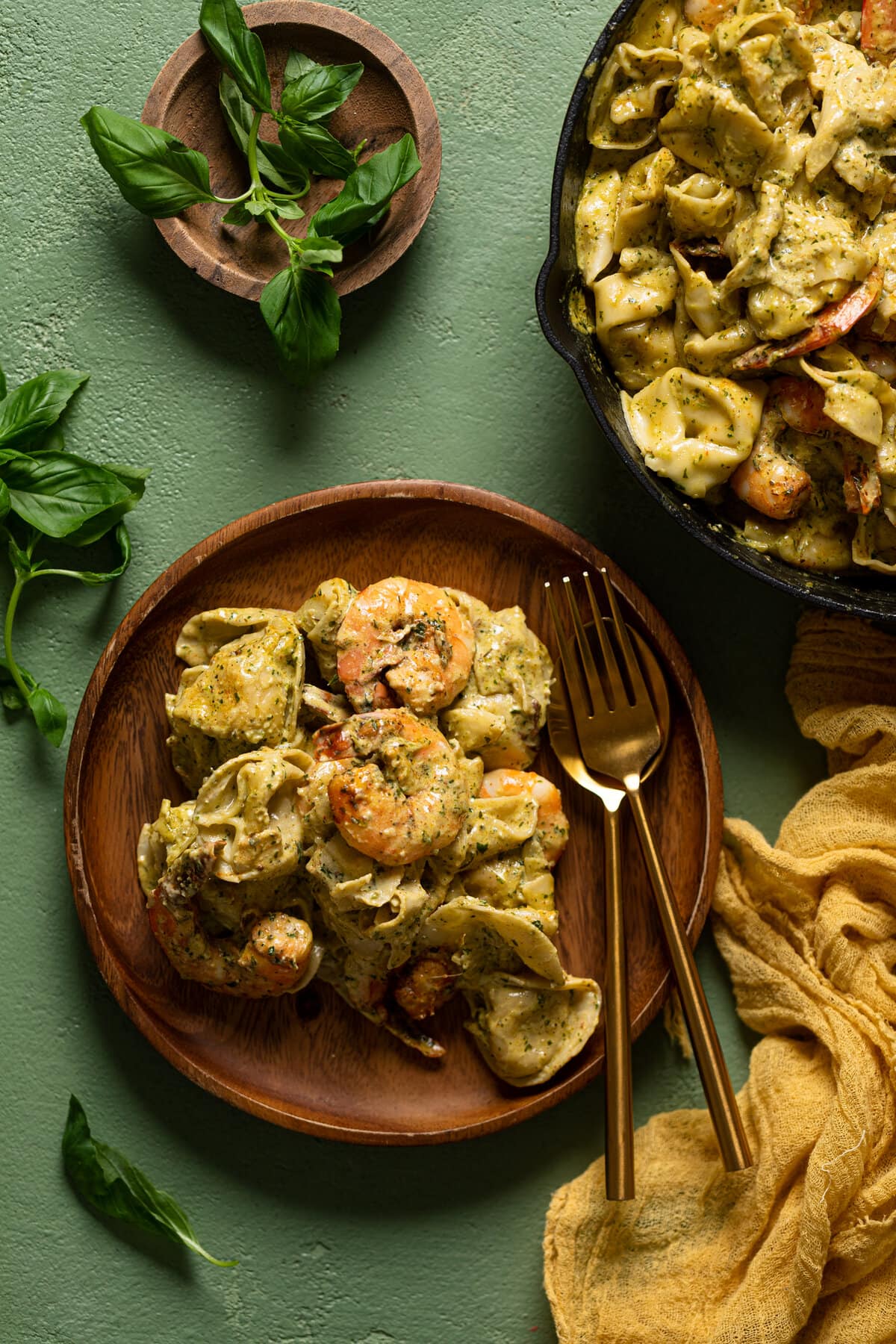 Creamy Shrimp Pesto Tortellini Pasta on a wooden plate with silverware