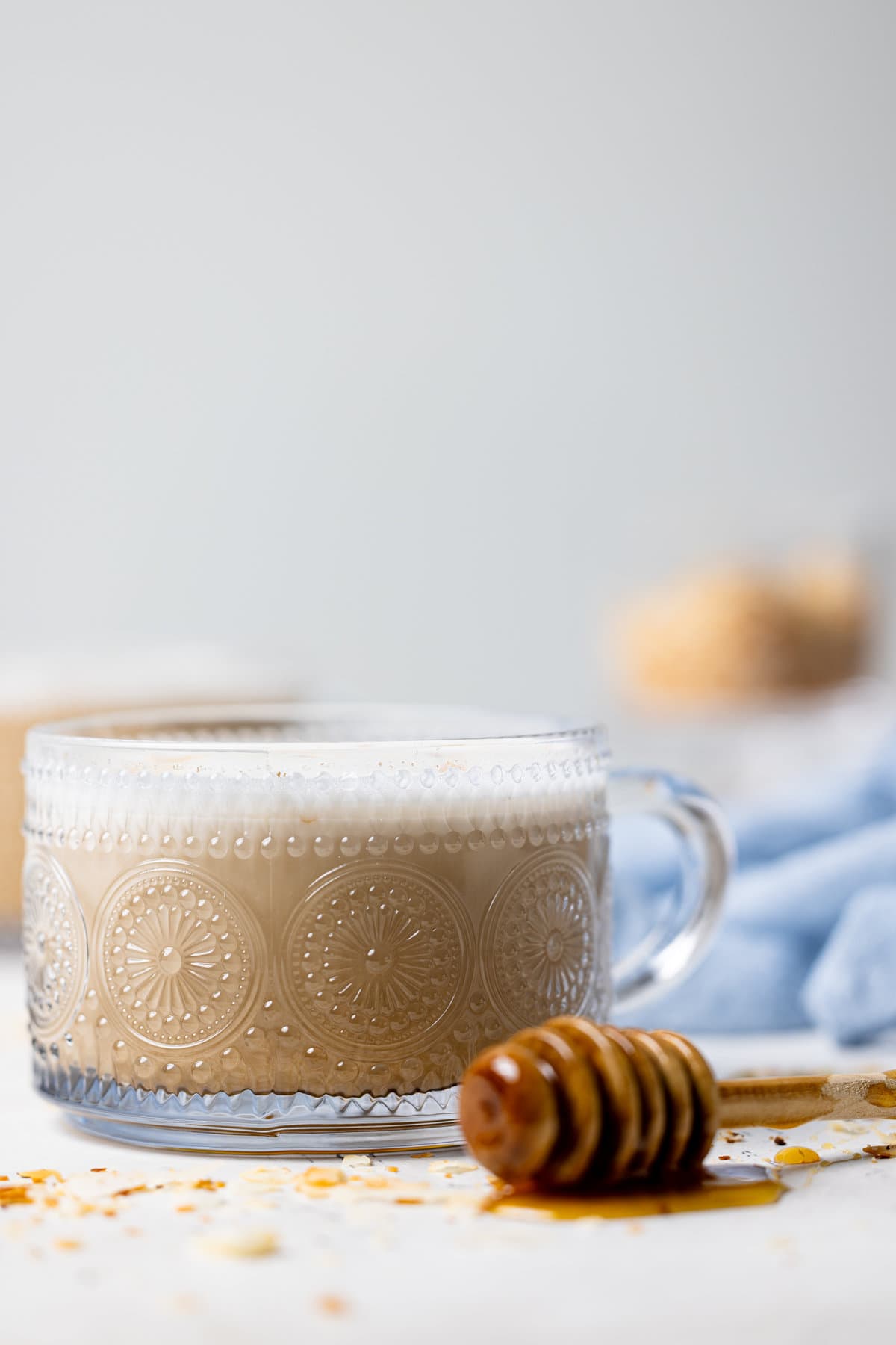 Glass of Toasted Coconut Honey Latte next to a honey dipper