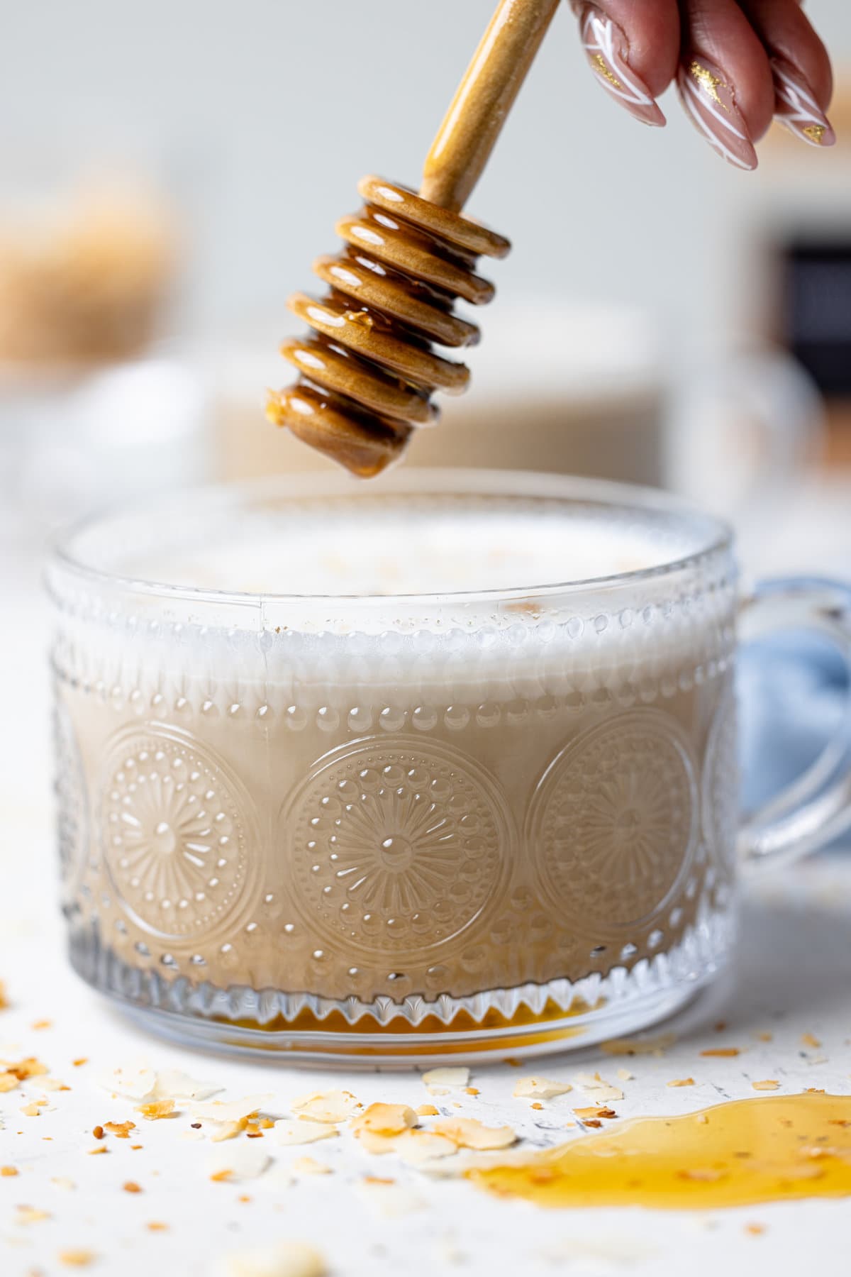 Honey dipper over a glass of Toasted Coconut Honey Latte 