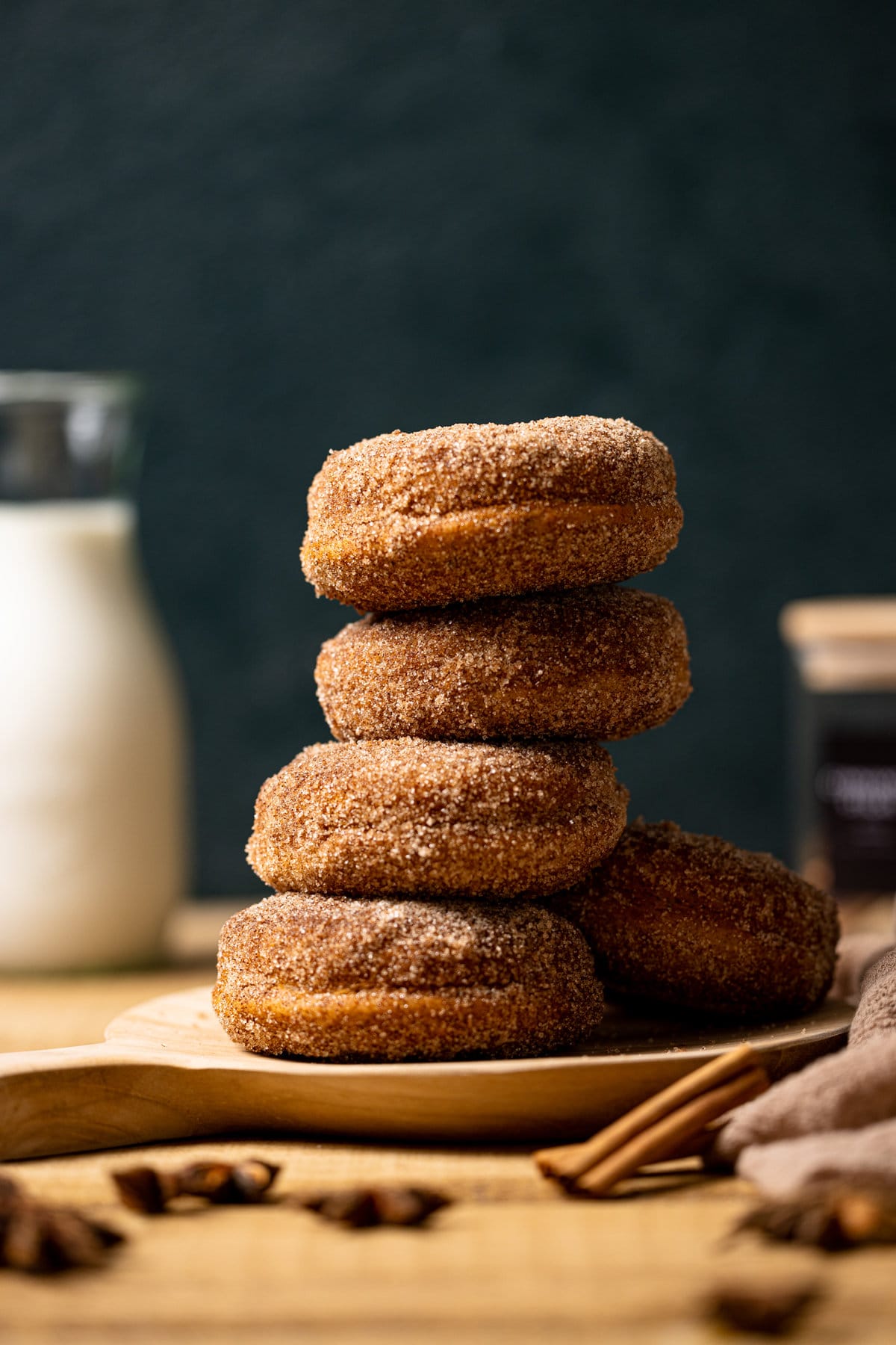 Stack of Baked Vegan Apple Cider Donuts on a wooden platter