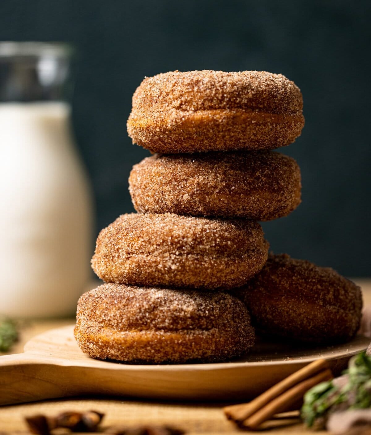 Stack of Baked Vegan Apple Cider Donuts on a wooden platter. Best fall recipes.