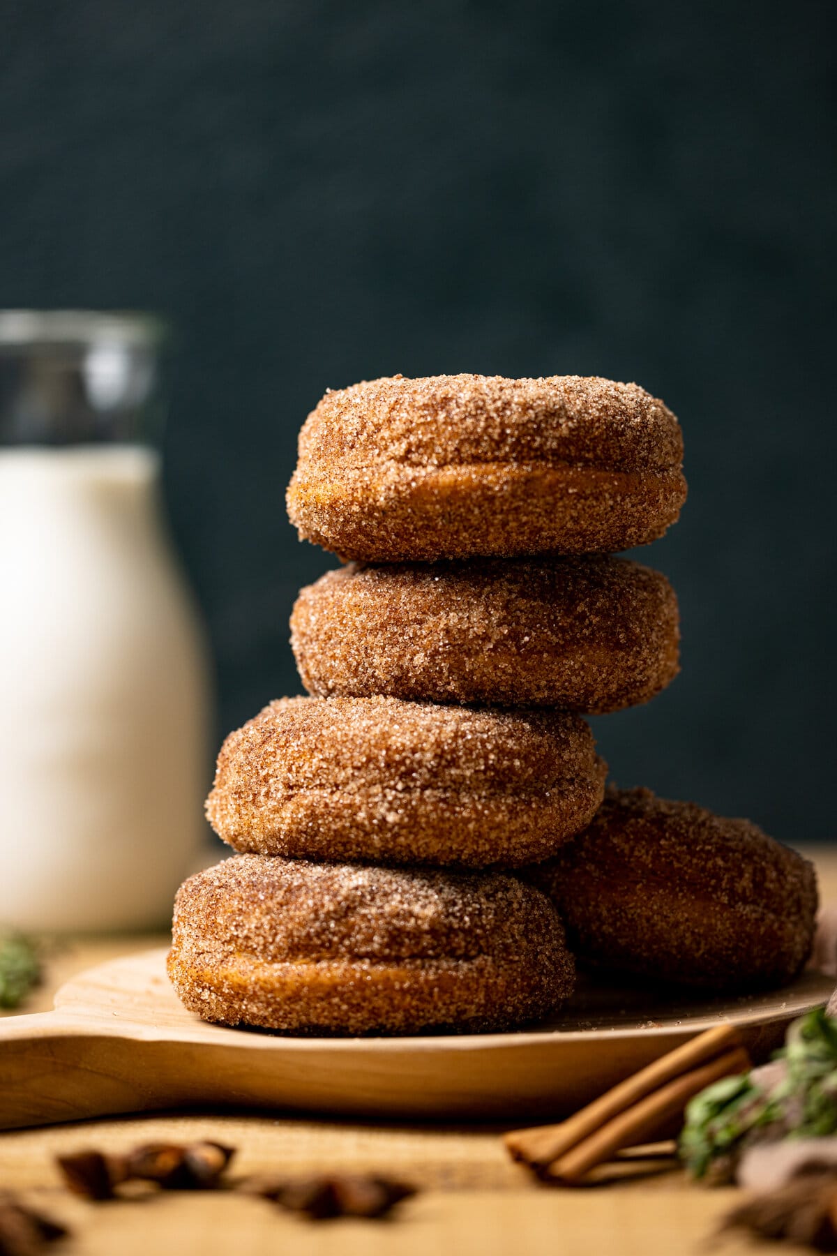 Stack of Baked Vegan Apple Cider Donuts on a wooden platter