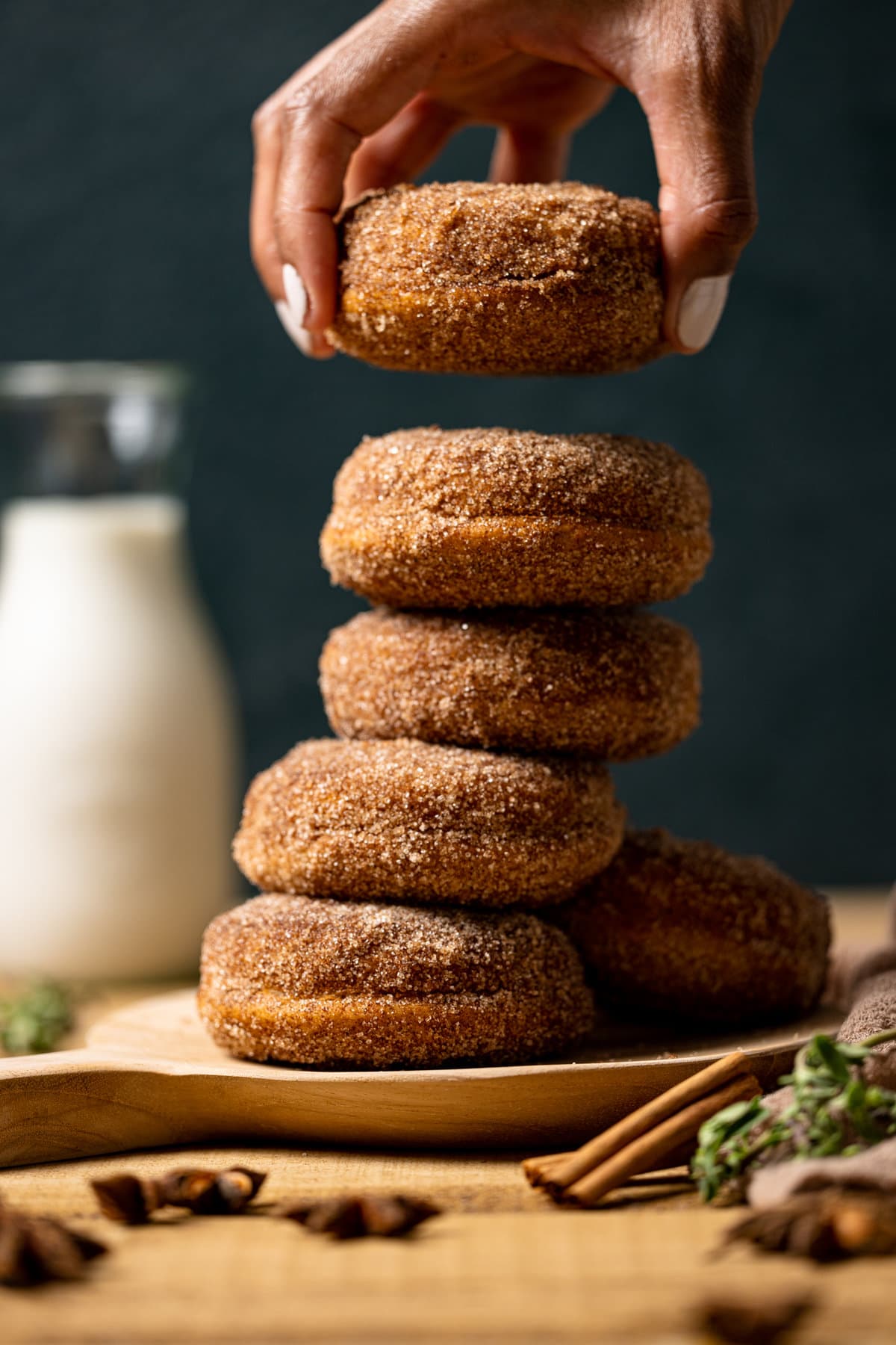 Hand grabbing a Baked Vegan Apple Cider Donut from a pile