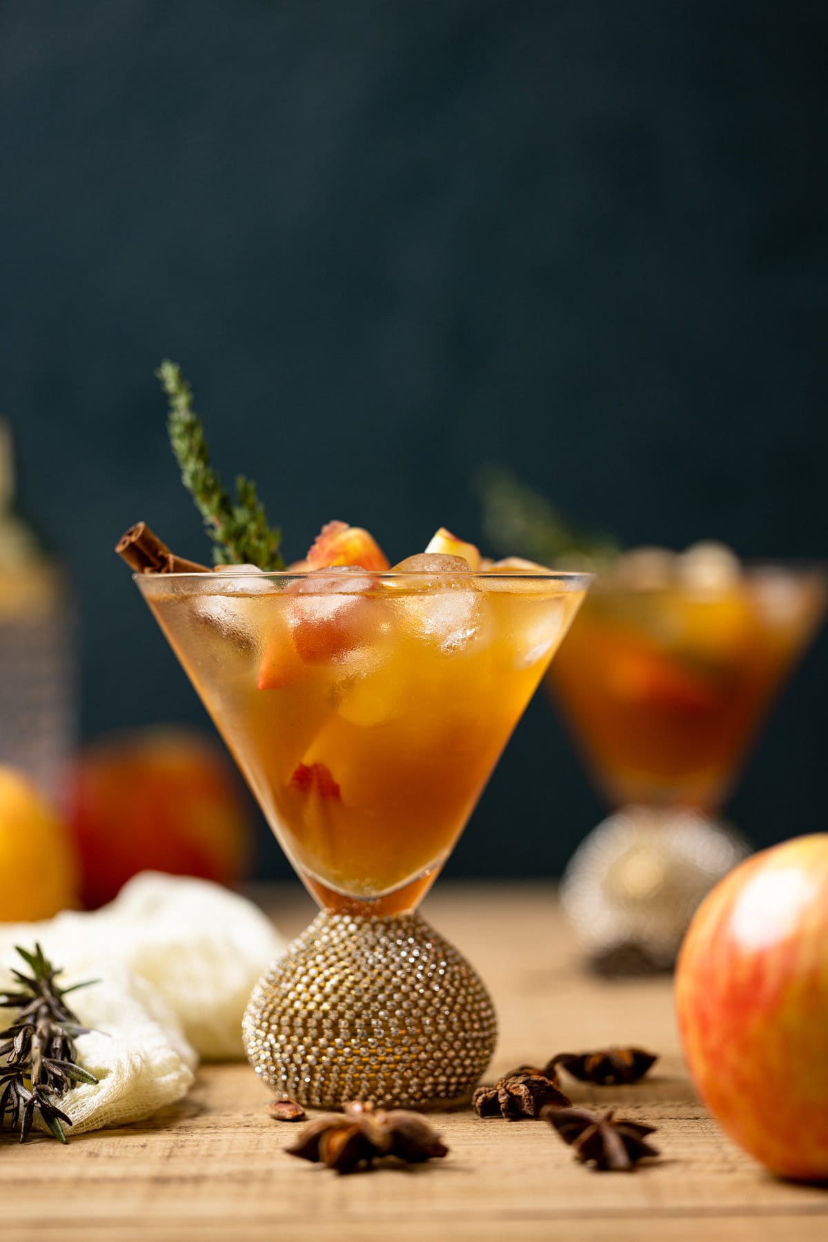 Apple Cider Mocktail in a jeweled cocktail glass with ice and a cinnamon stick
