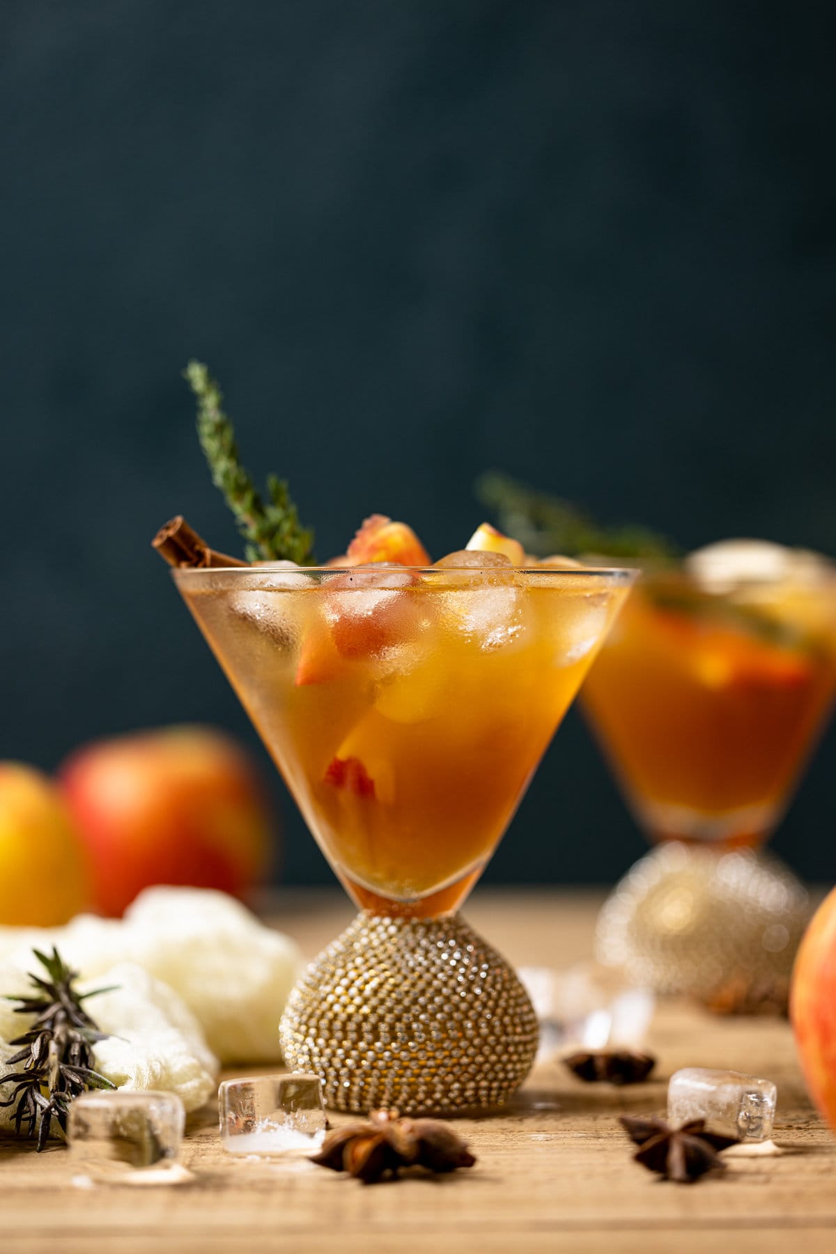 Apple Cider Mocktail in a jeweled cocktail glass with ice and a cinnamon stick
