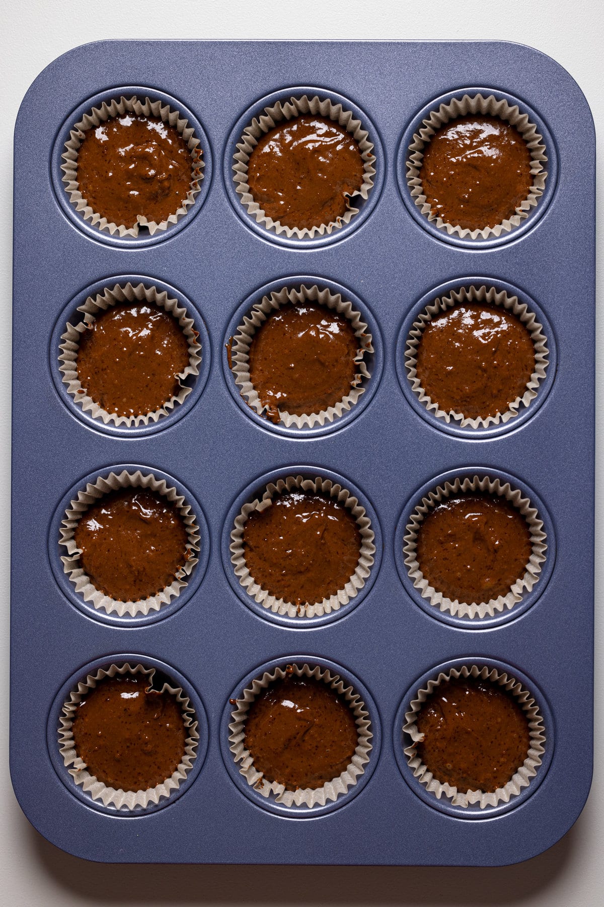 Muffin pan full of Chocolate Sweet Potato Cupcake batter