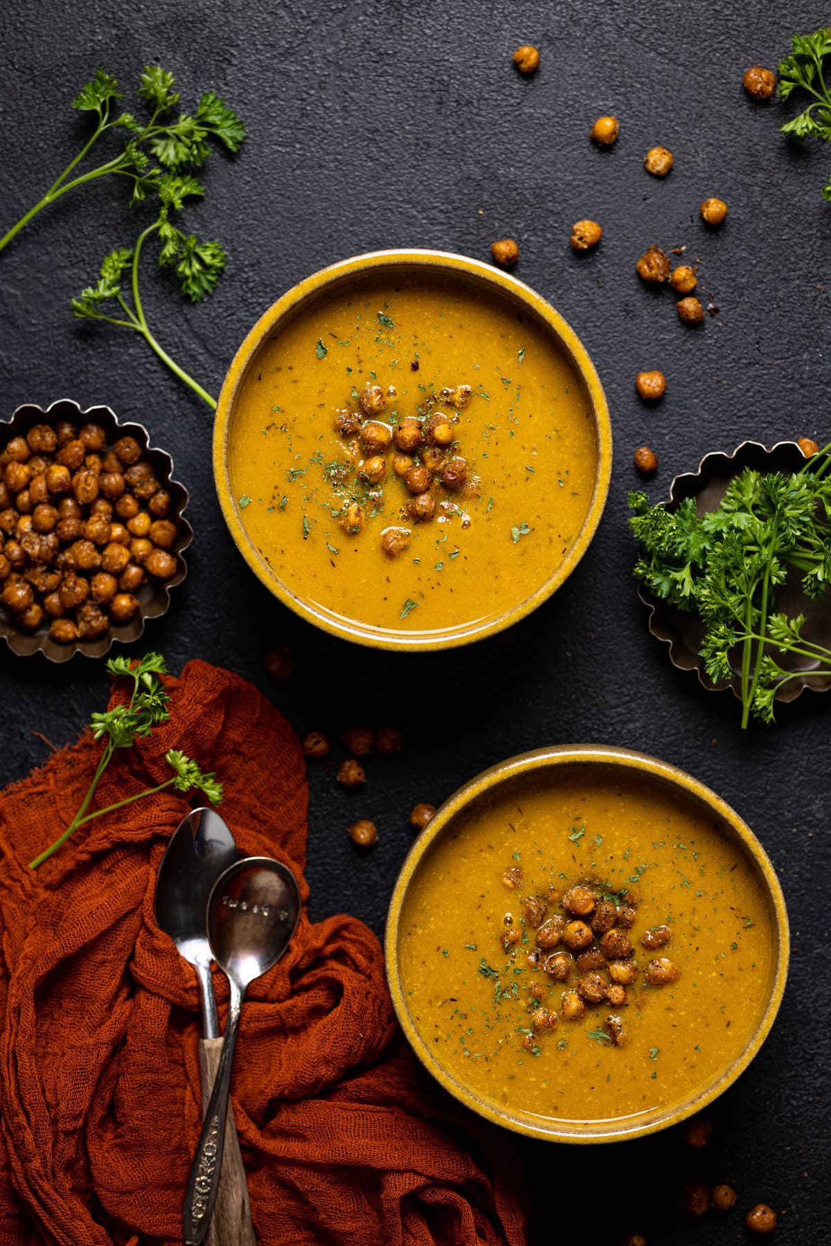 Overhead shot of two bowls of Spicy Curry Pumpkin Soup with Chickpeas