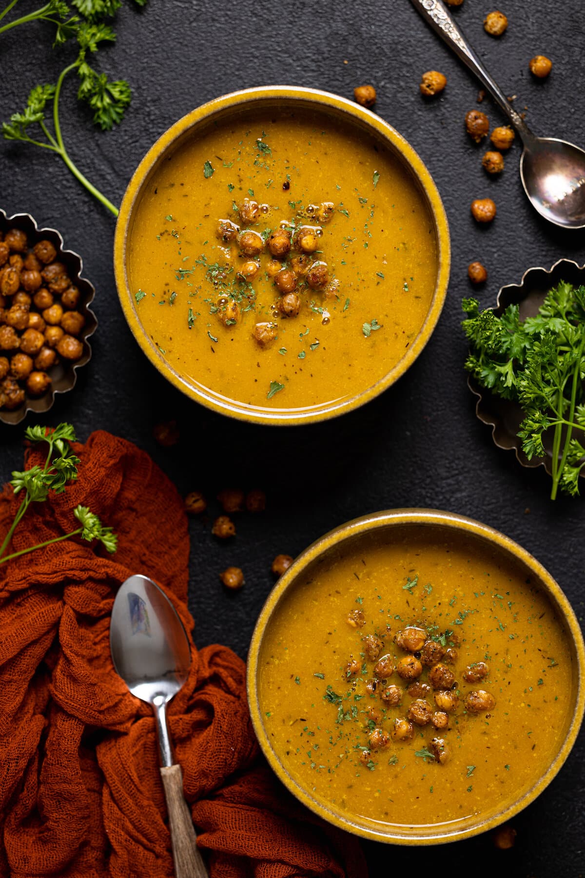 Overhead shot of two bowls of Spicy Curry Pumpkin Soup with Chickpeas