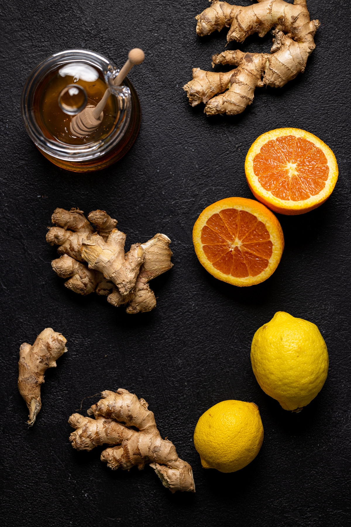 Ingredients for Citrus Ginger Turmeric Ice Cubes with Tea including honey, lemons, and ginger