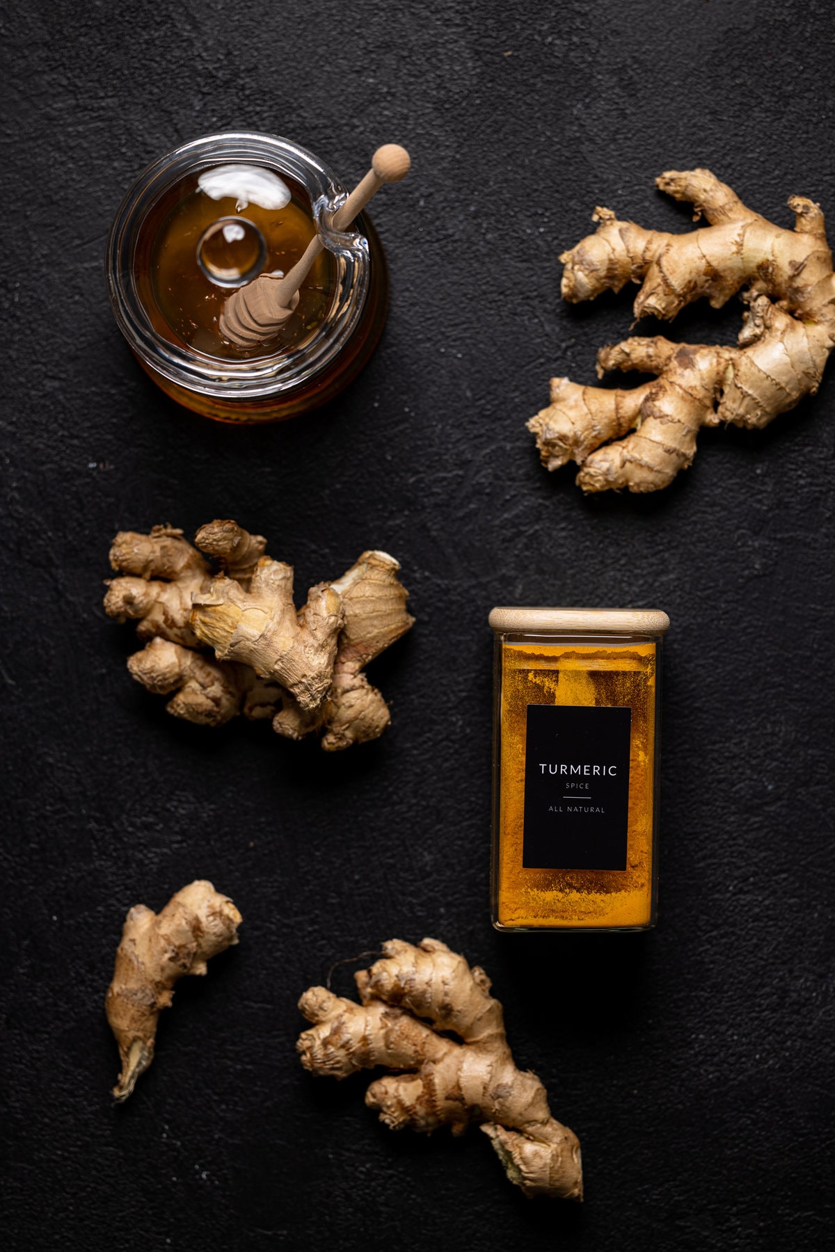 Jar of turmeric, jar of honey, and ginger roots
