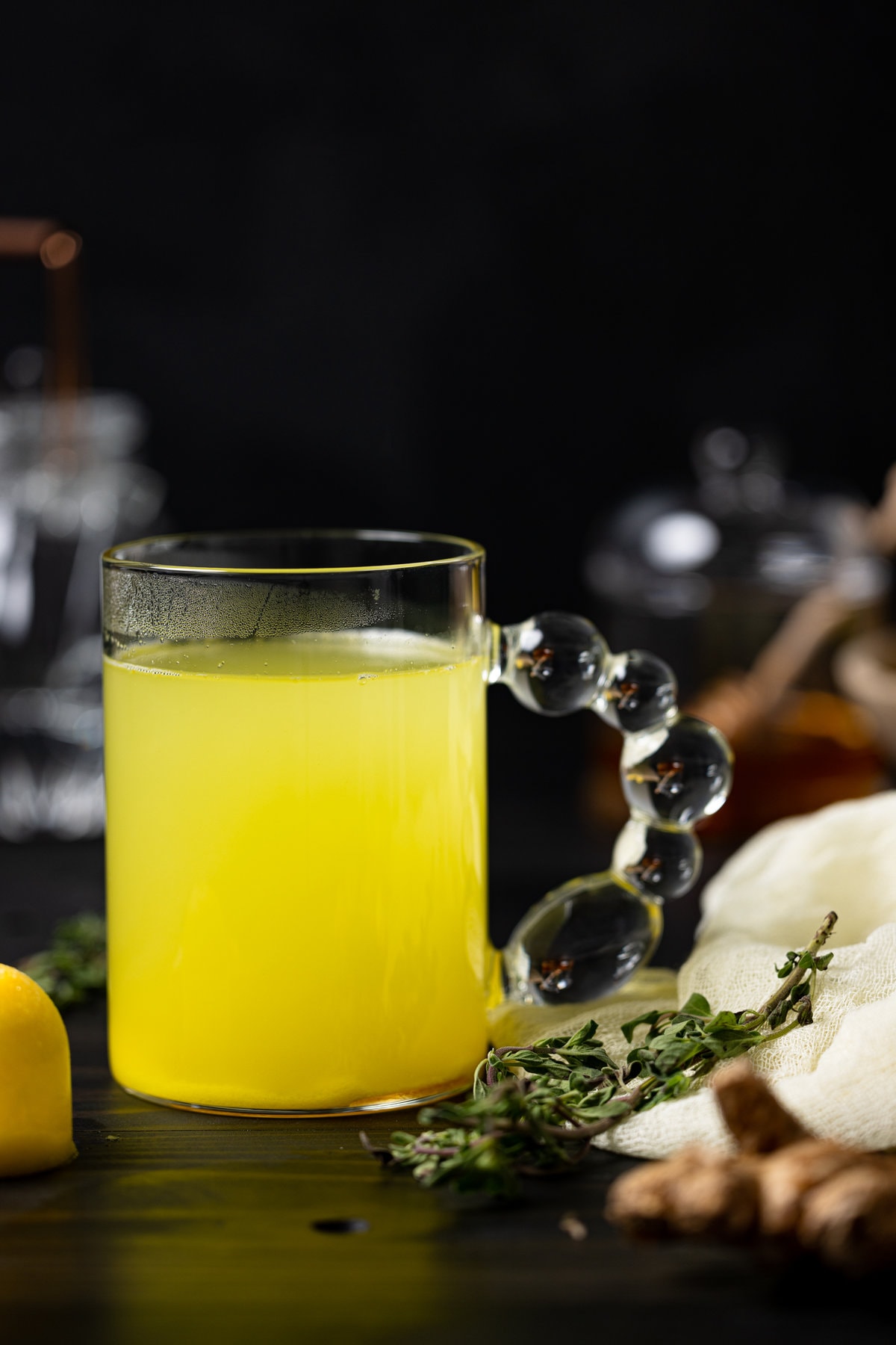 Bubble-handled glass of ginger turmeric ice cubes with tea