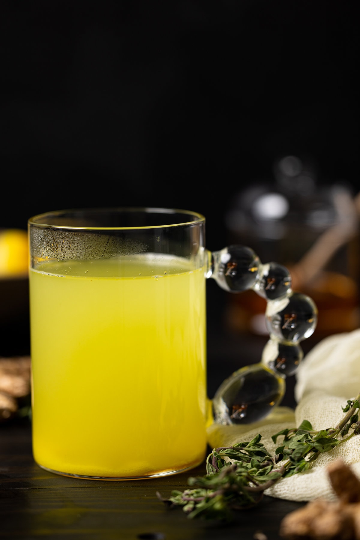 Closeup of a glass of Citrus Ginger Turmeric Ice Cubes with Tea