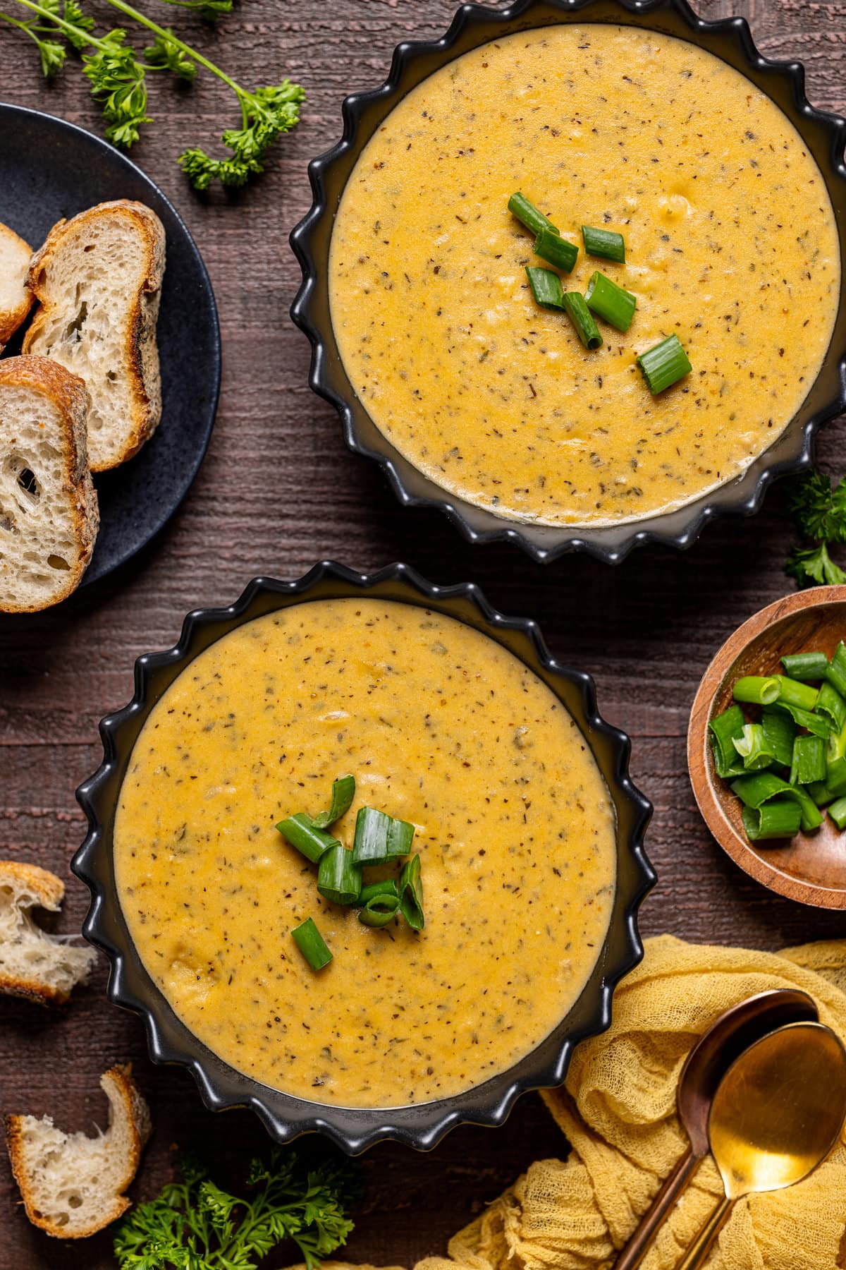 Overhead shot of two bowls of Hearty Cheddar Garlic Herb Potato Soup