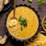 Bowl of Hearty Cheddar Garlic Herb Potato Soup with a spoon