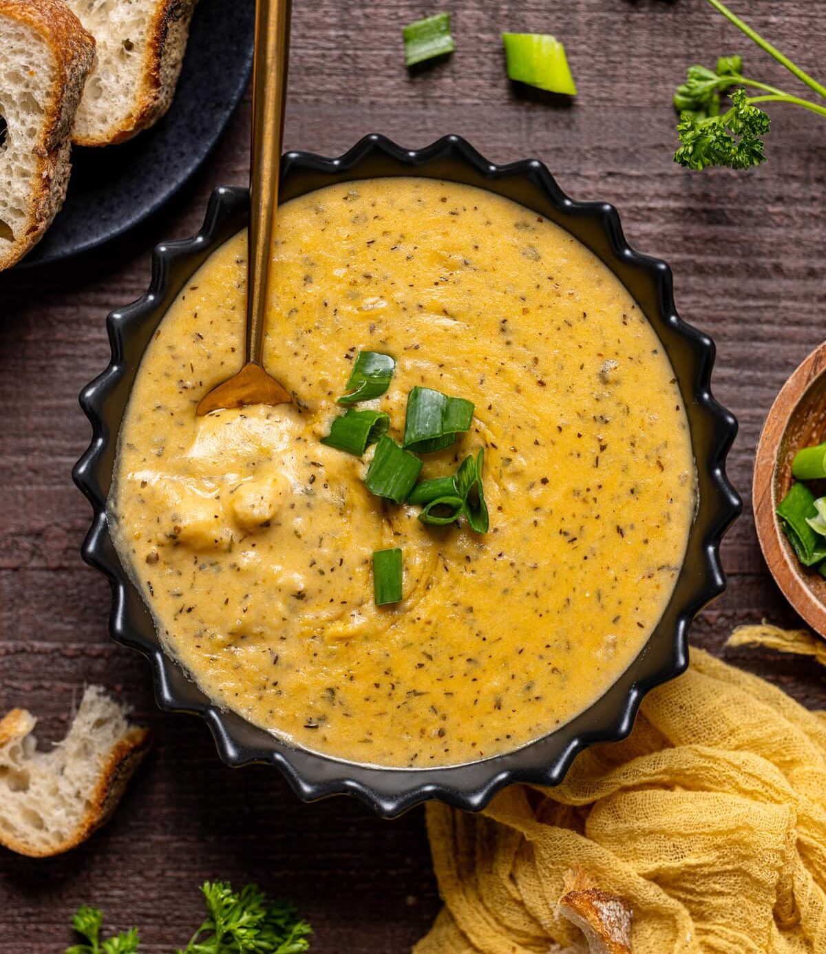 Bowl of Hearty Cheddar Garlic Herb Potato Soup with a spoon