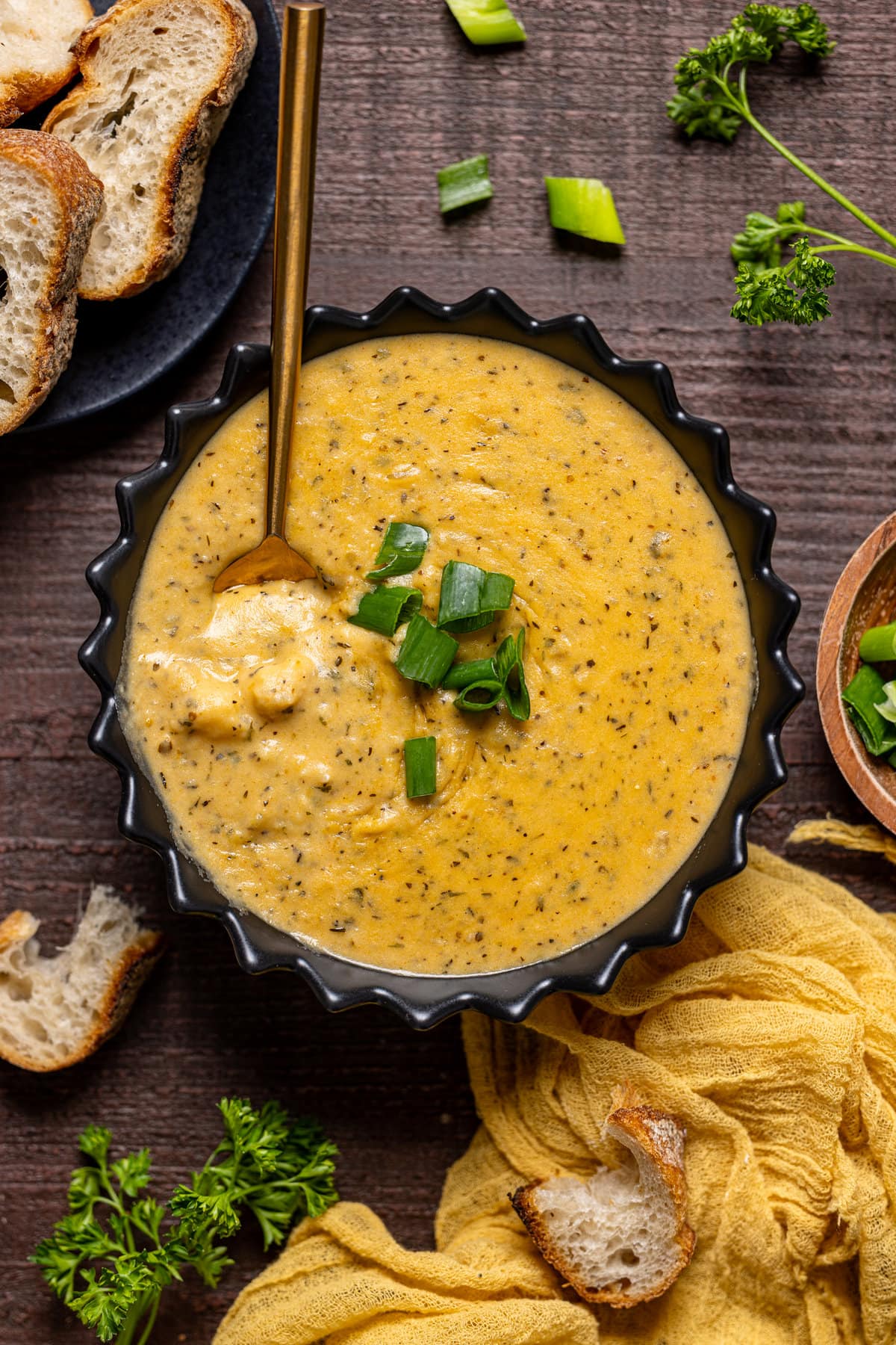 Bowl of Hearty Cheddar Garlic Herb Potato Soup with a spoon