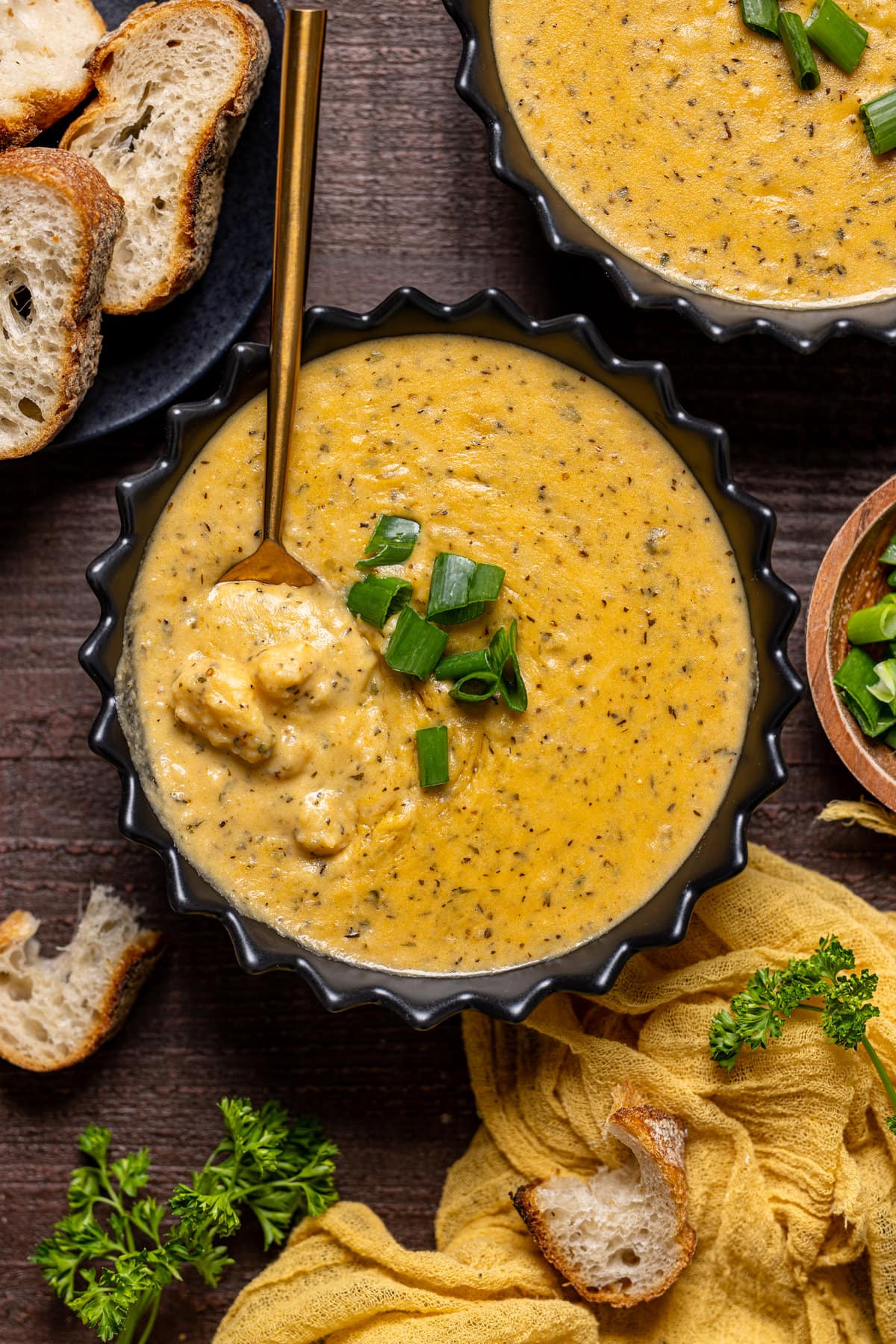 Overhead shot of a bowl of Hearty Cheddar Garlic Herb Potato Soup with a spoon