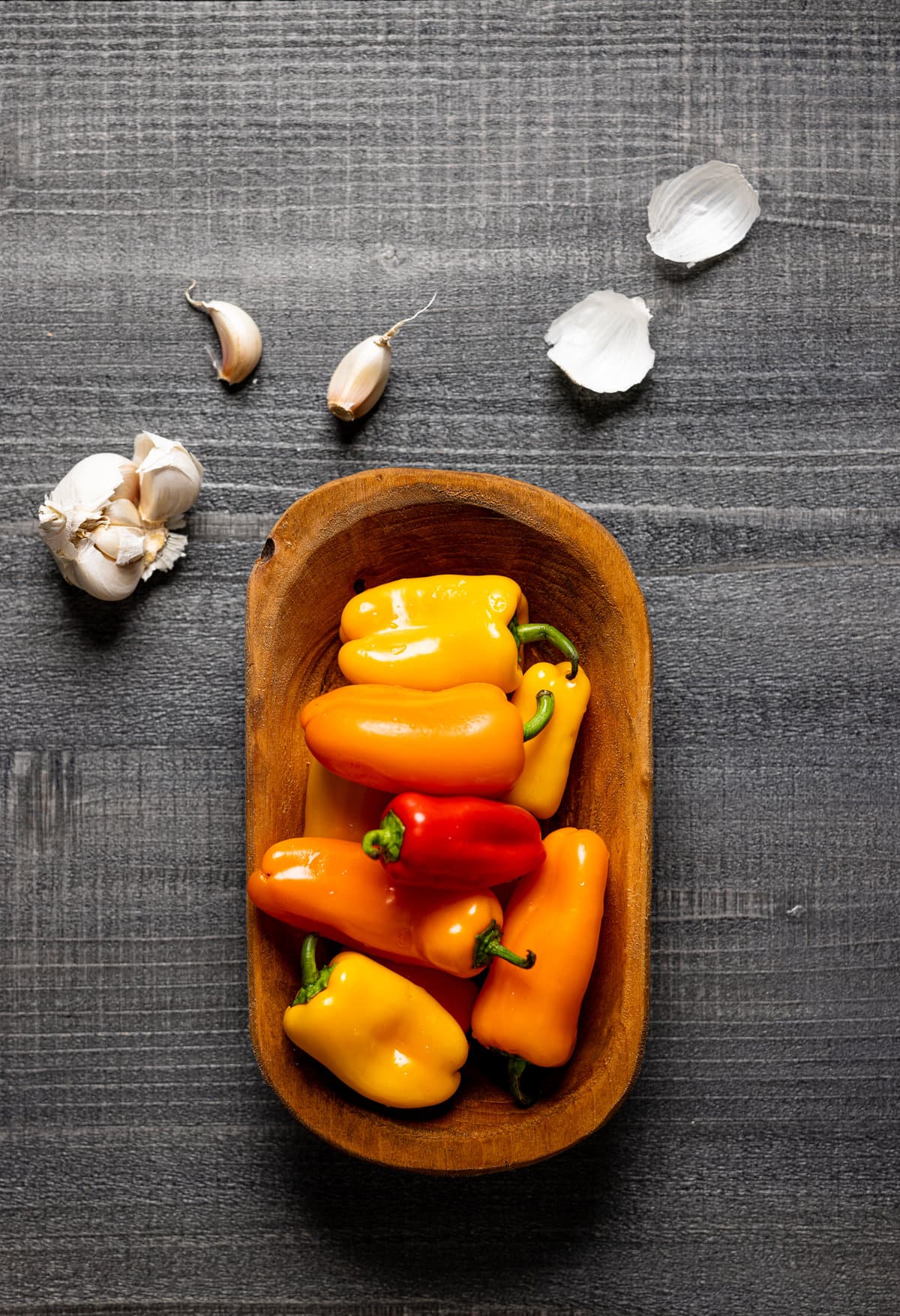 Wooden bowl of peppers with garlic