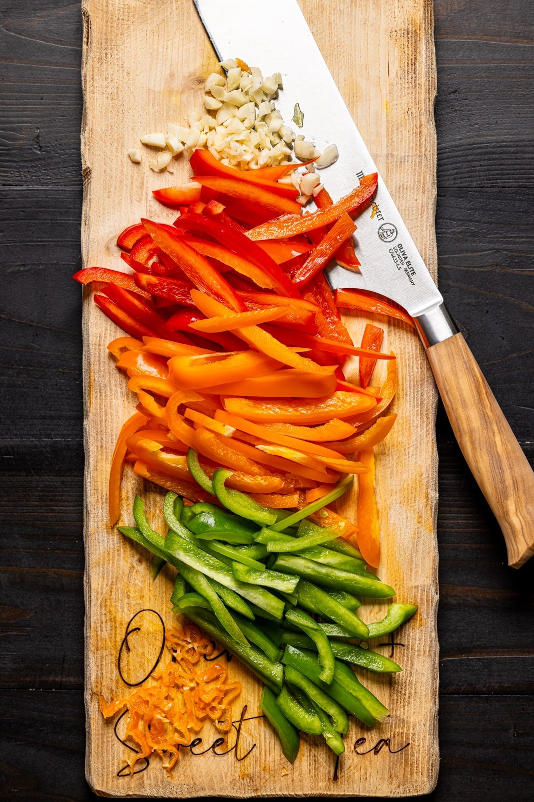 Chopped veggies on a cutting board with a knife.