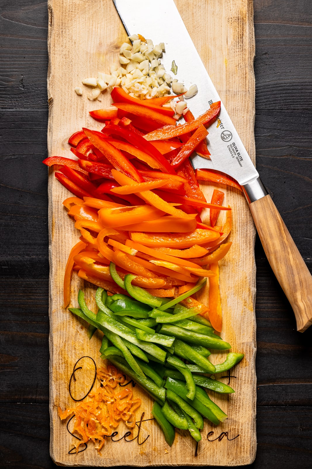 Chopped veggies on a cutting board with a knife.