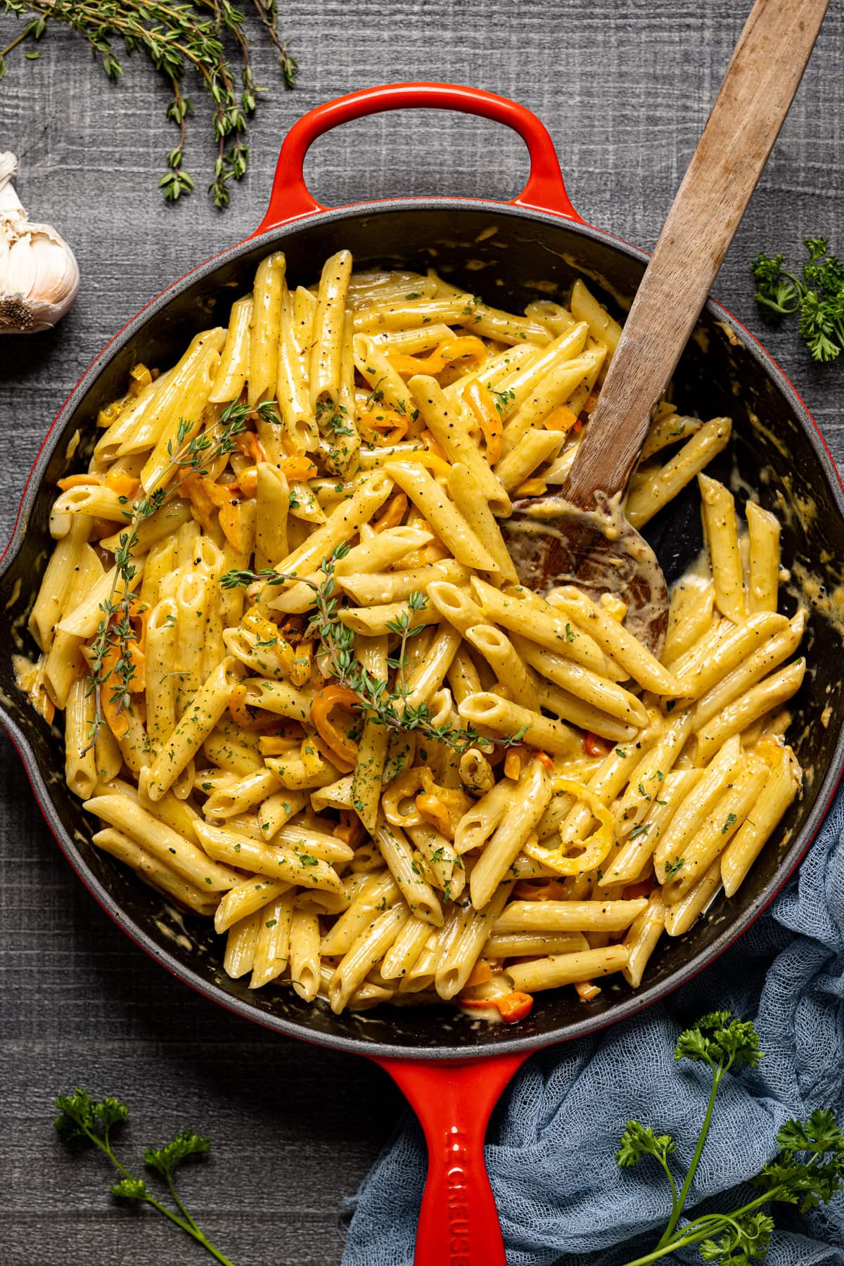 Wooden spoon stirring a skillet of Creamy Jamaican Rasta Pasta