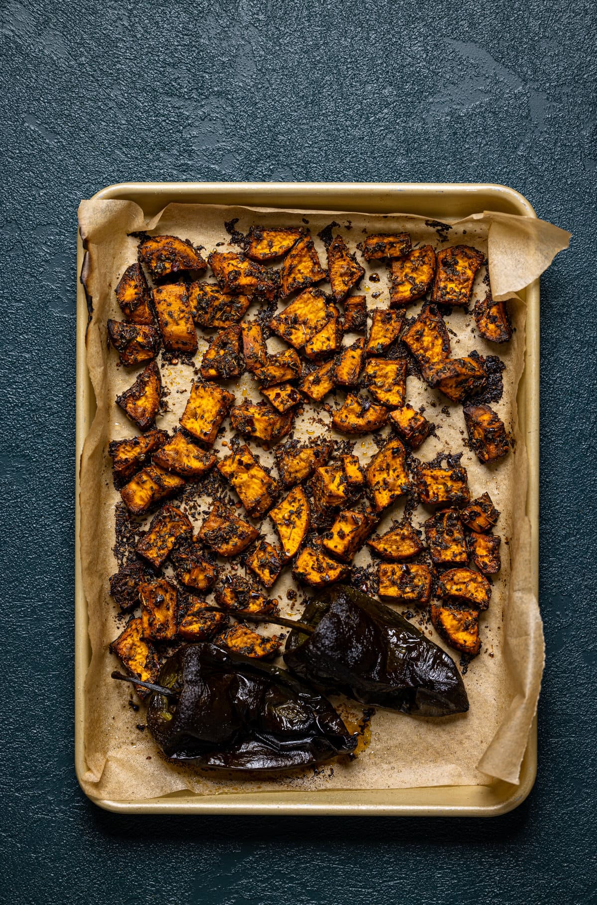 Sheet pan of seasoned and roasted peppers and diced sweet potatoes