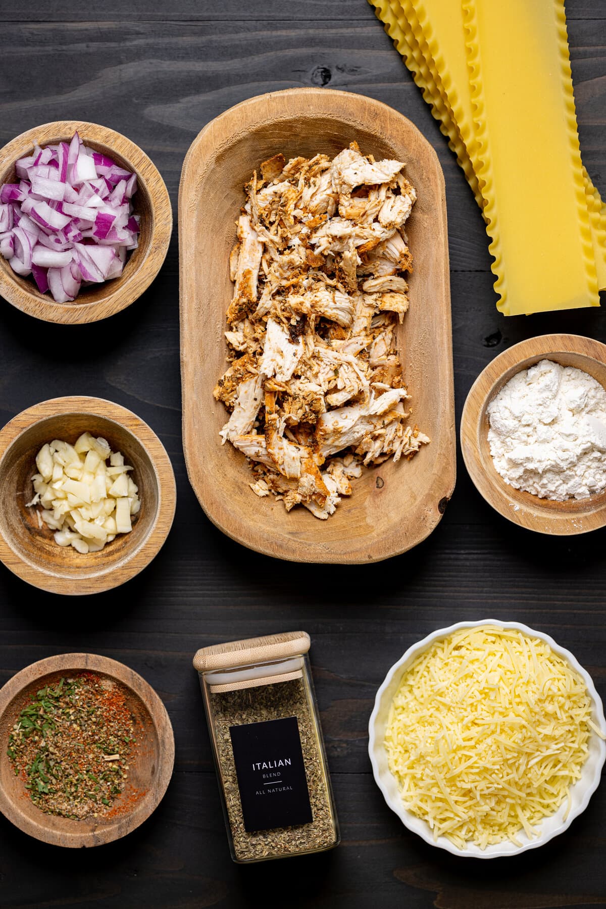 Ingredients for Creamy White Chicken Lasagna Soup including red onion, garlic, and Italian seasoning