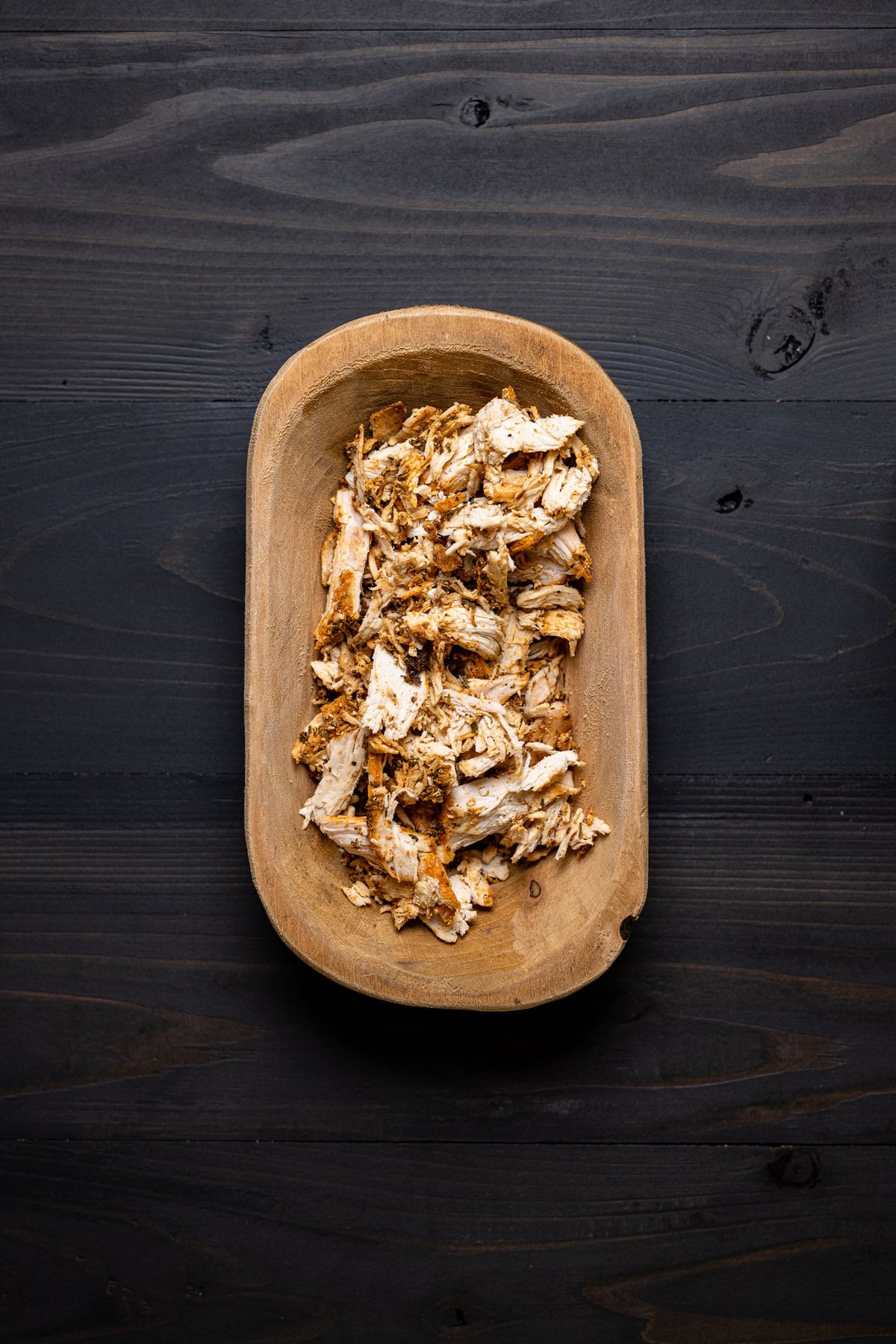 Wooden bowl of shredded chicken