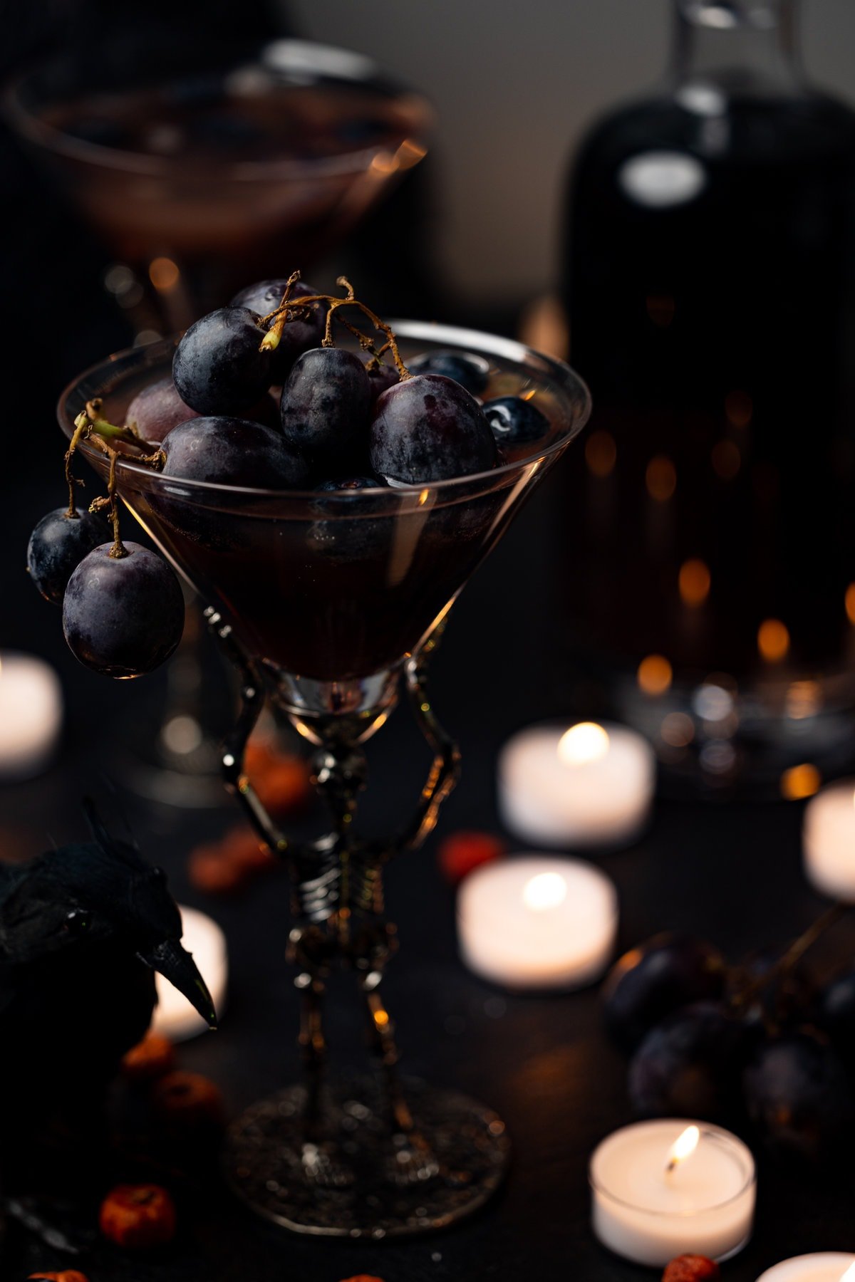 Halloween Witches Brew Mocktail in skeleton glassware overflowing with black grapes