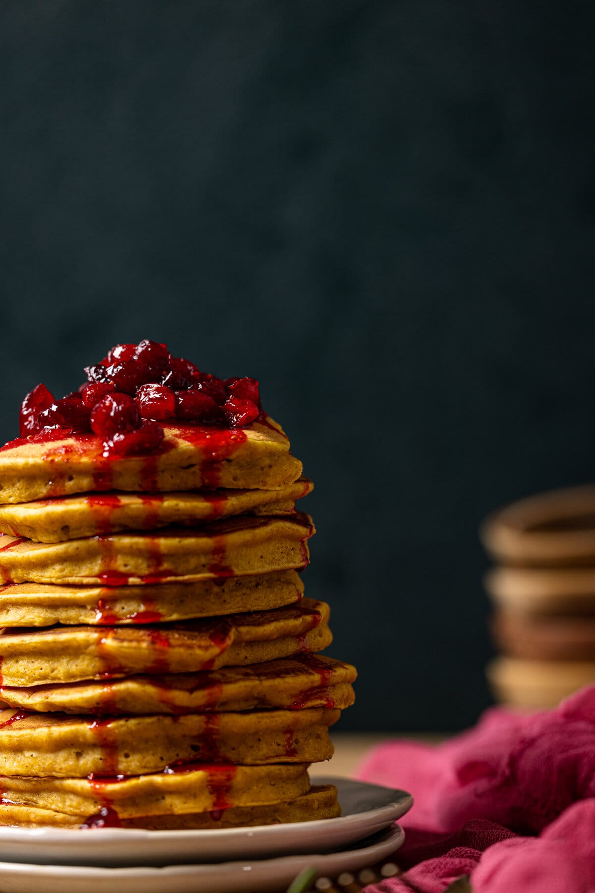 Large stack of Apple Cider Pumpkin Pancakes topped with Cranberries