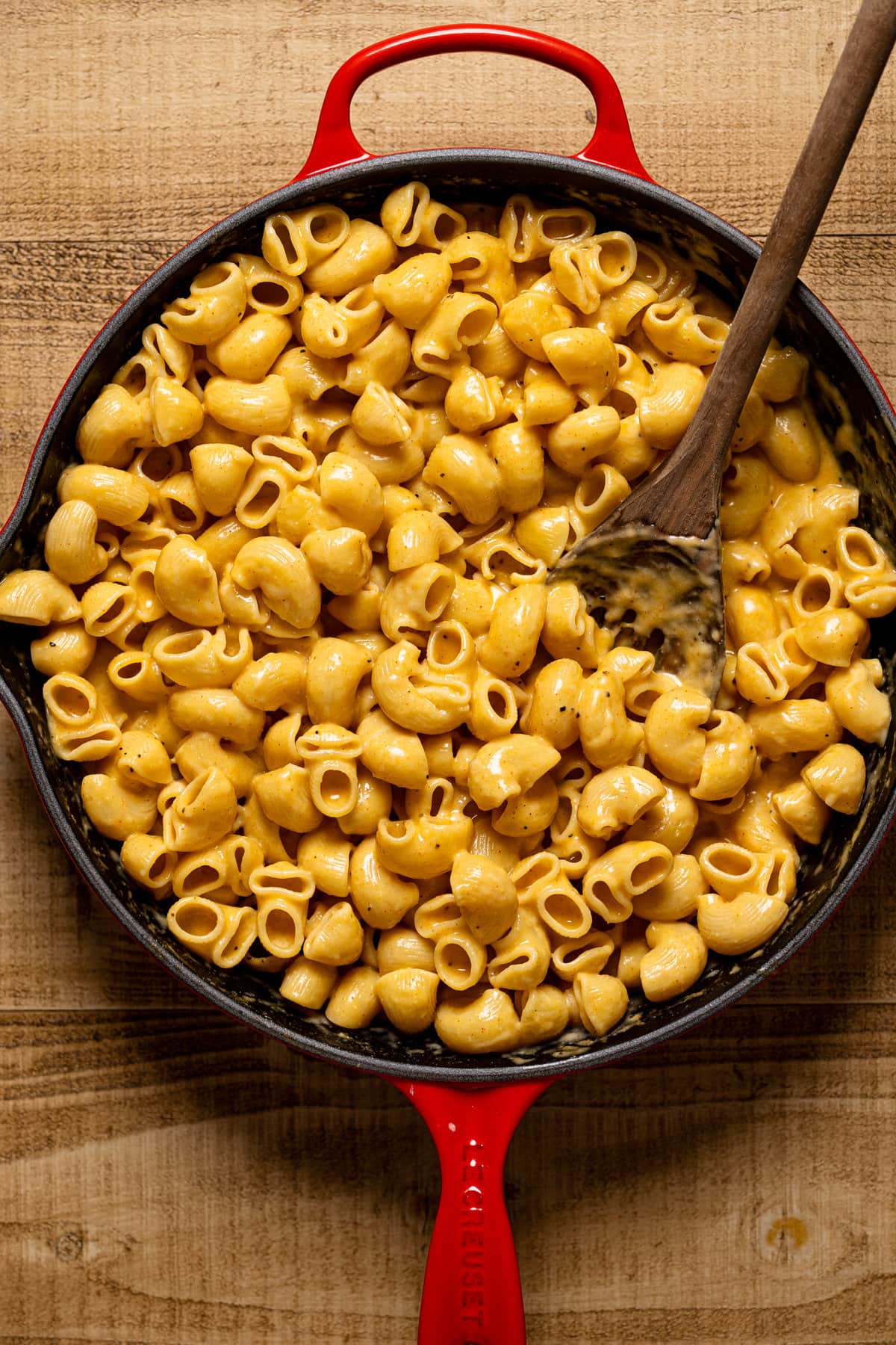 Wooden spoon stirring a pan of Creamy Stovetop Southern Mac and Cheese