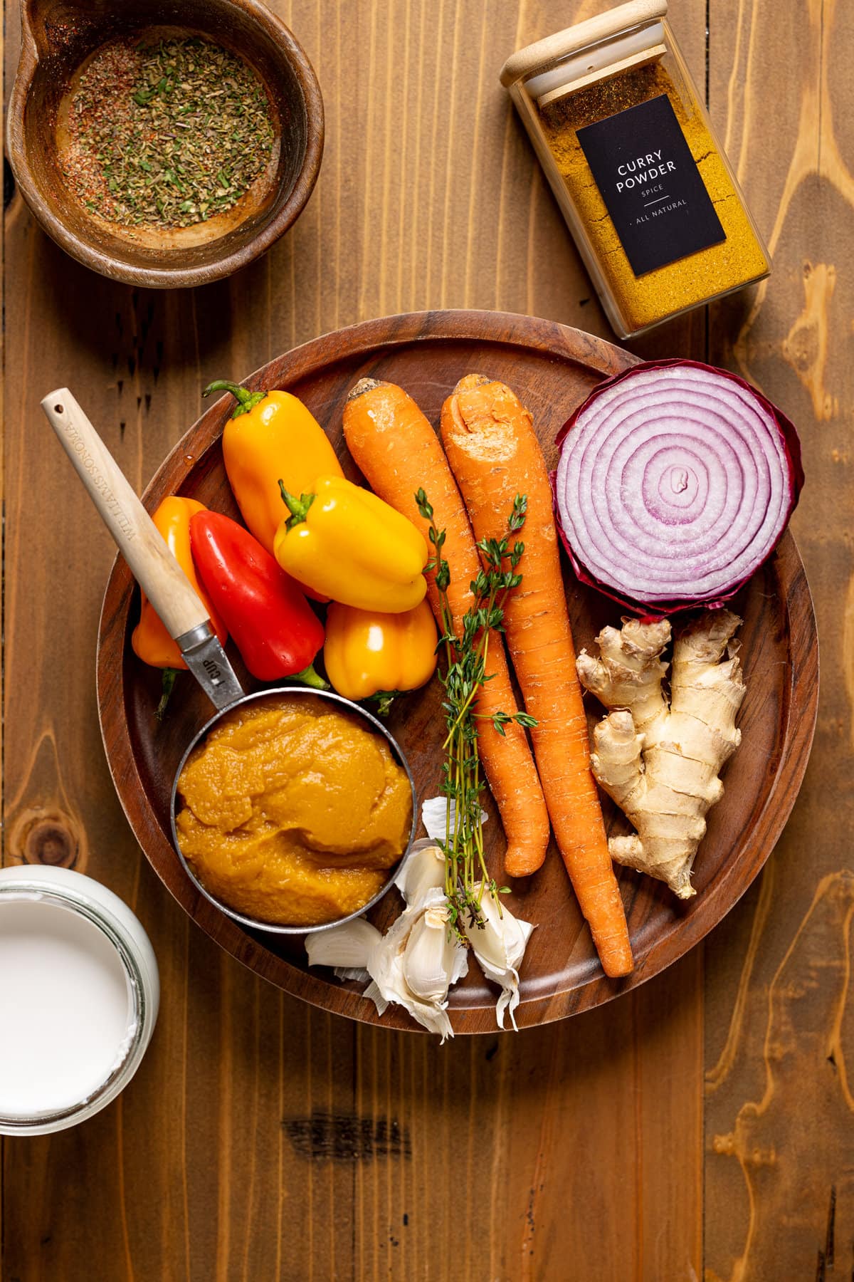 Bowl of ingredients including pumpkin puree, carrots, peppers, and red onion