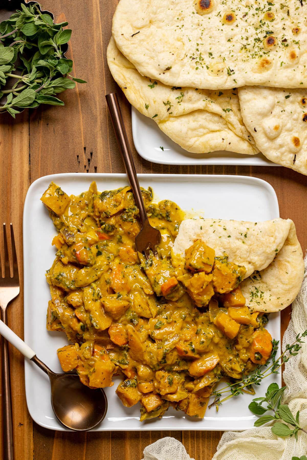 Overhead shot of a plate of Vegan Pumpkin Curry Butternut Squash with naan