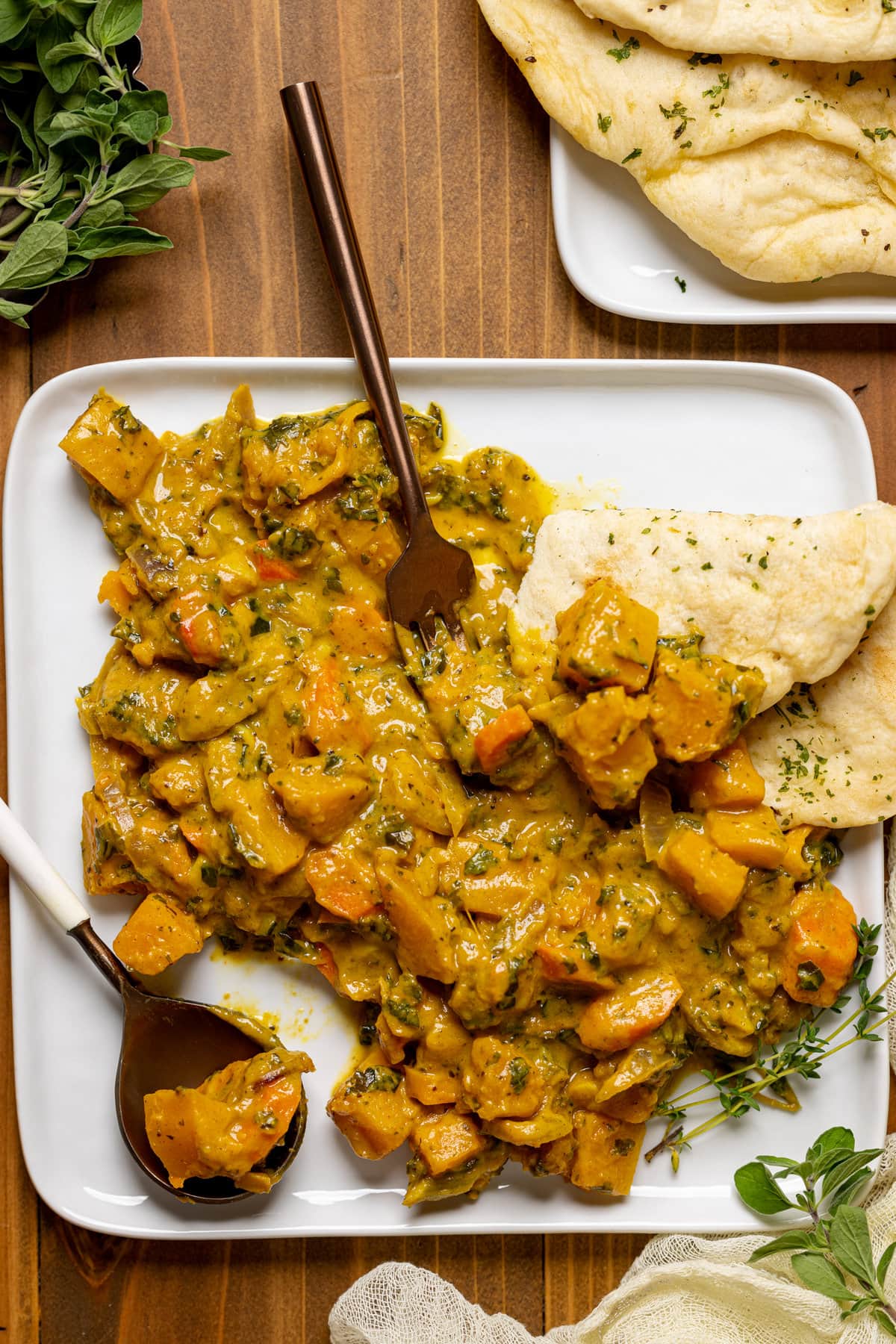 Overhead shot of a plate of Vegan Pumpkin Curry Butternut Squash with naan