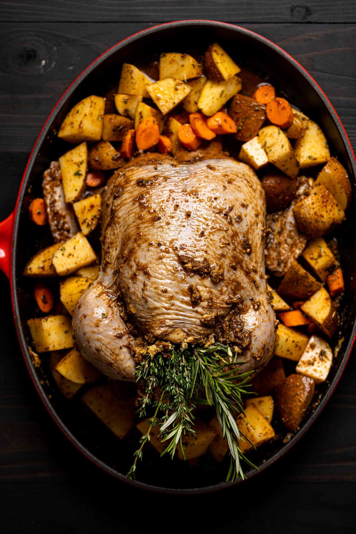 Raw, seasoned chicken surrounded by chopped vegetables