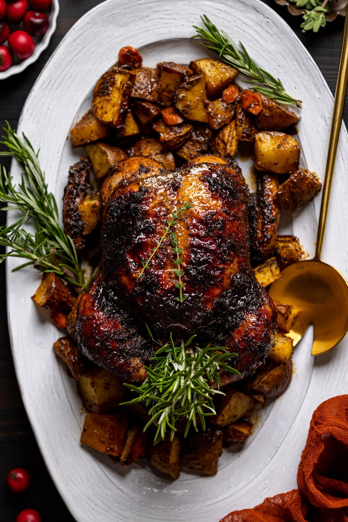Jerk Whole Roast Chicken on a serving platter surrounded by chopped vegetables