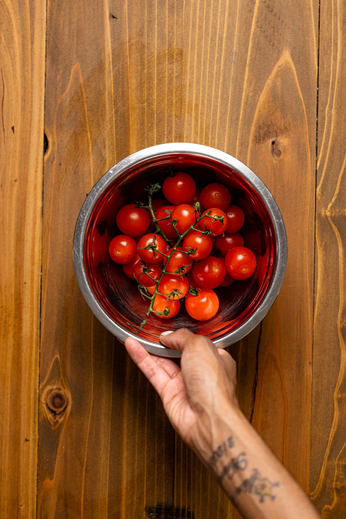 Hand holding a bowl of tomatoes