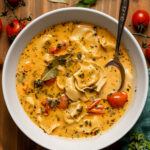 Bowl of creamy Tuscan tortellini soup with a spoon