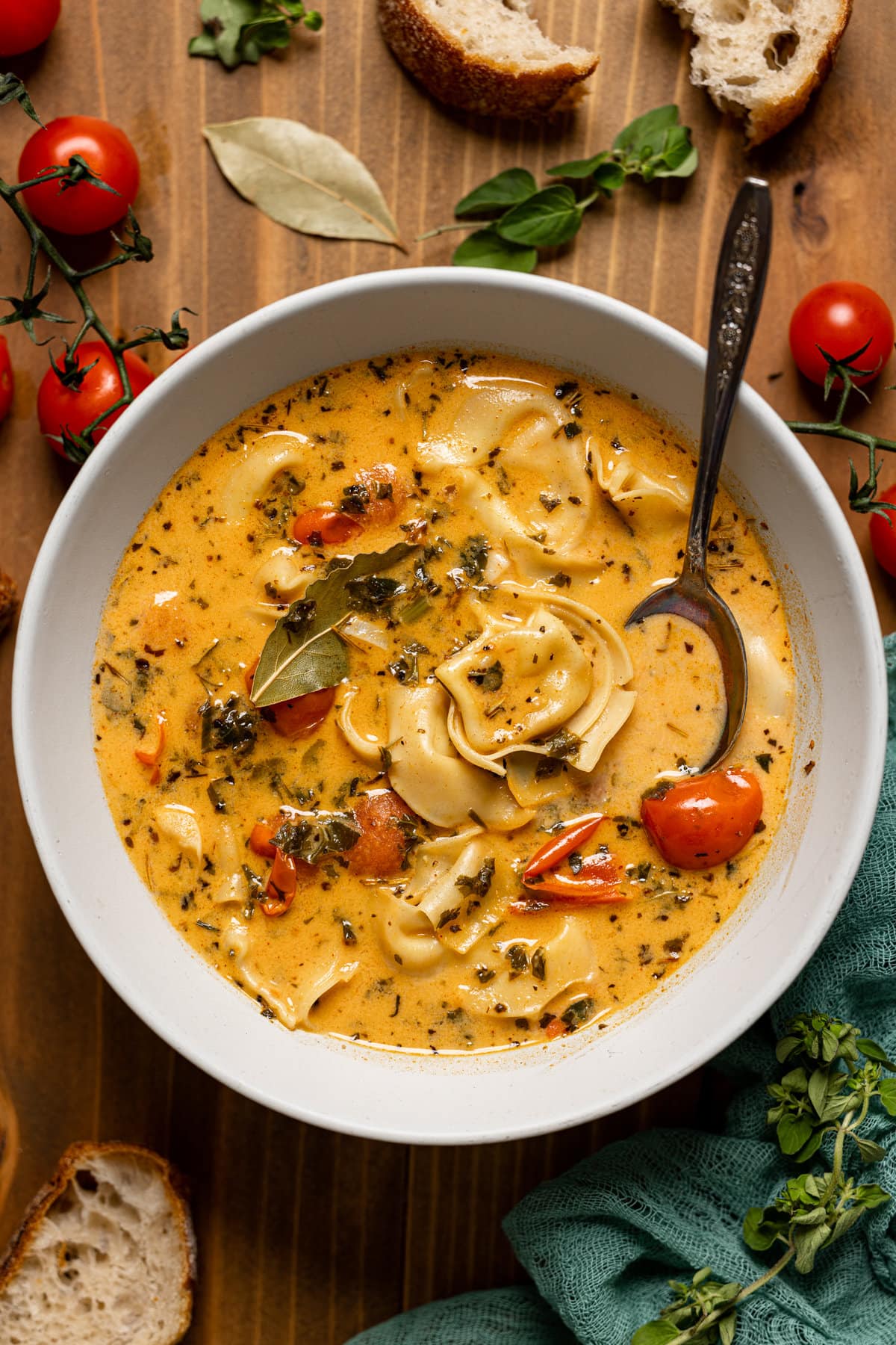 Bowl of creamy Tuscan tortellini soup with a spoon. A great healthy easy dinner idea.