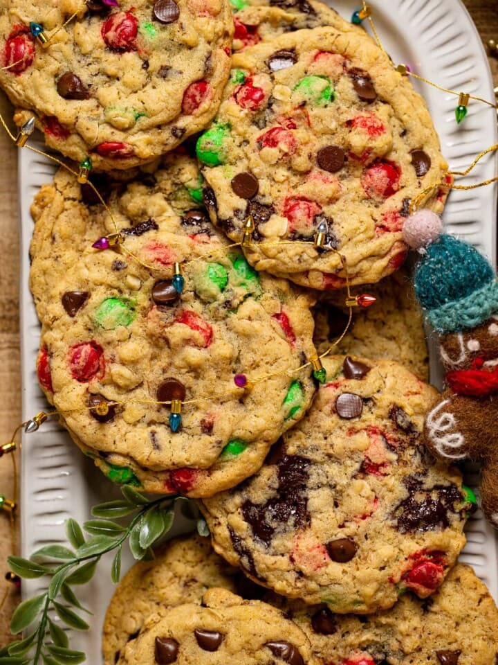 Plate of Christmas Monster Cookies topped with a string of tiny Christmas lights