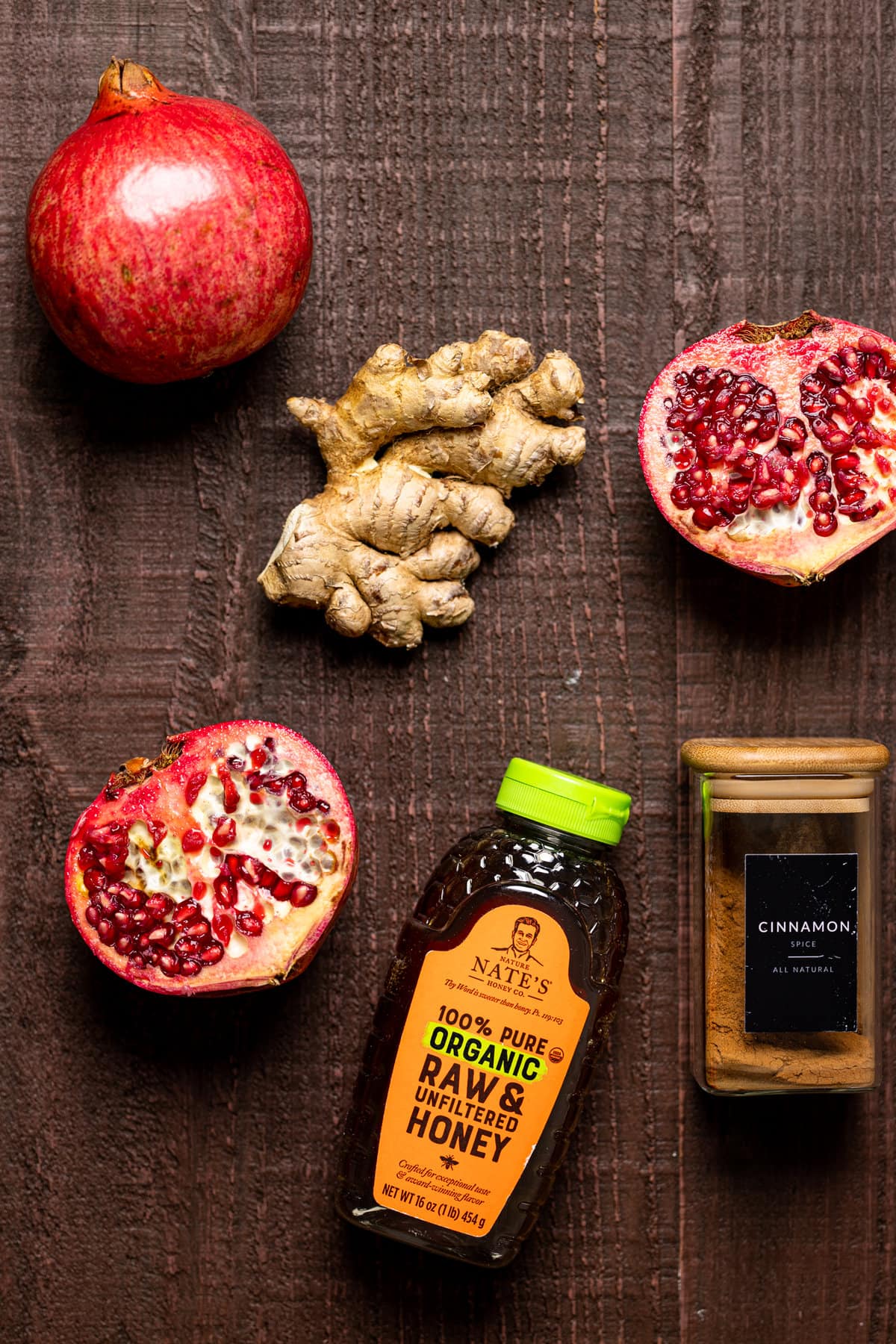 Ingredients for Holiday Pomegranate Ginger Mocktail including honey, cinnamon, and pomegranates