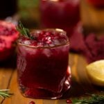 Closeup of a Holiday Pomegranate Ginger Mocktail in a gold-rimmed glass